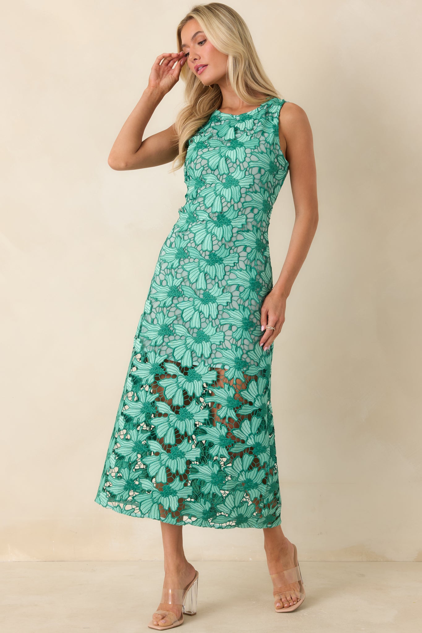 Elegant green midi dress with detailed lace texture and refined shape.