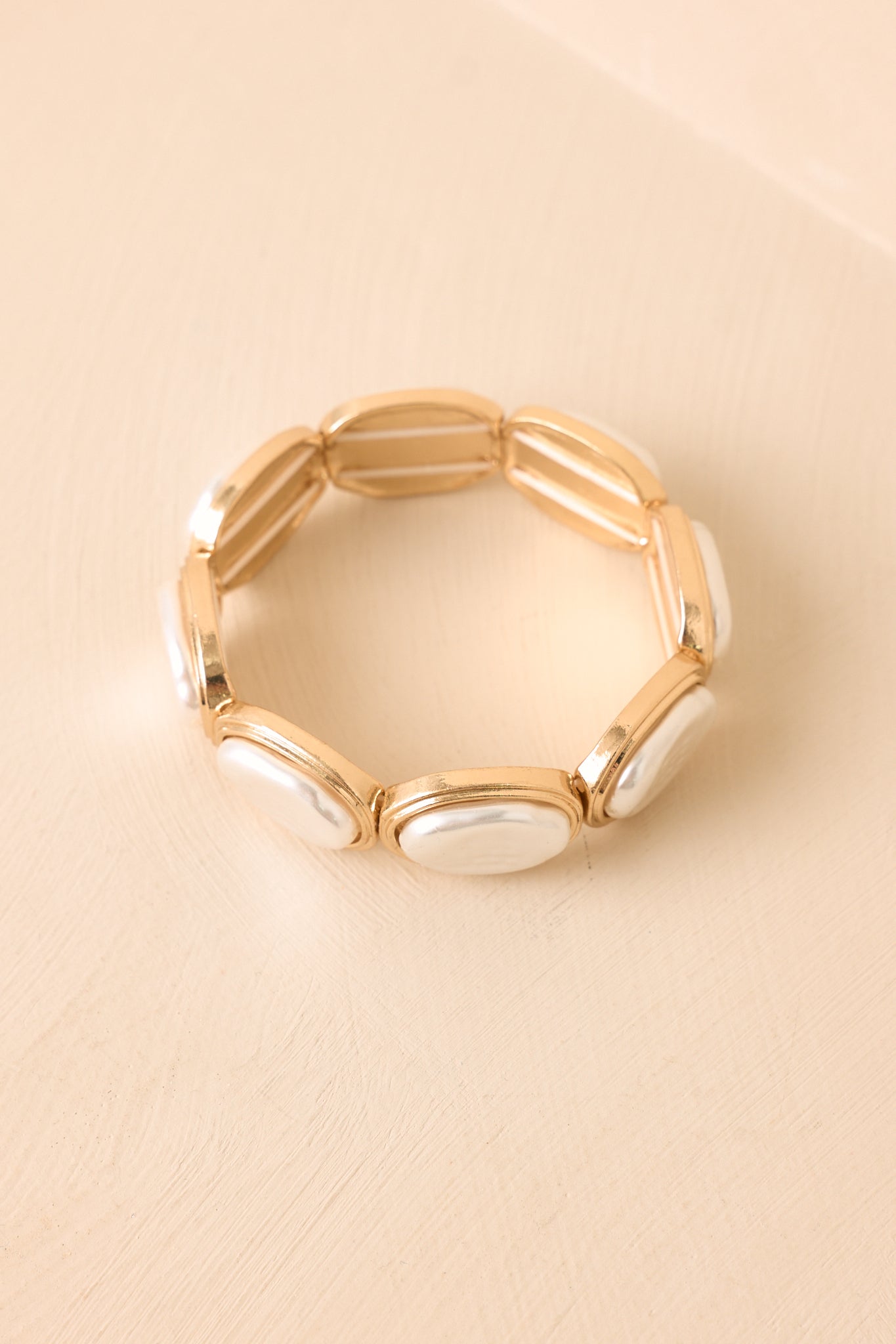 Textured gold bracelet showcasing smooth pearlescent details, a flexible stretch design, and timeless jewelry styling.