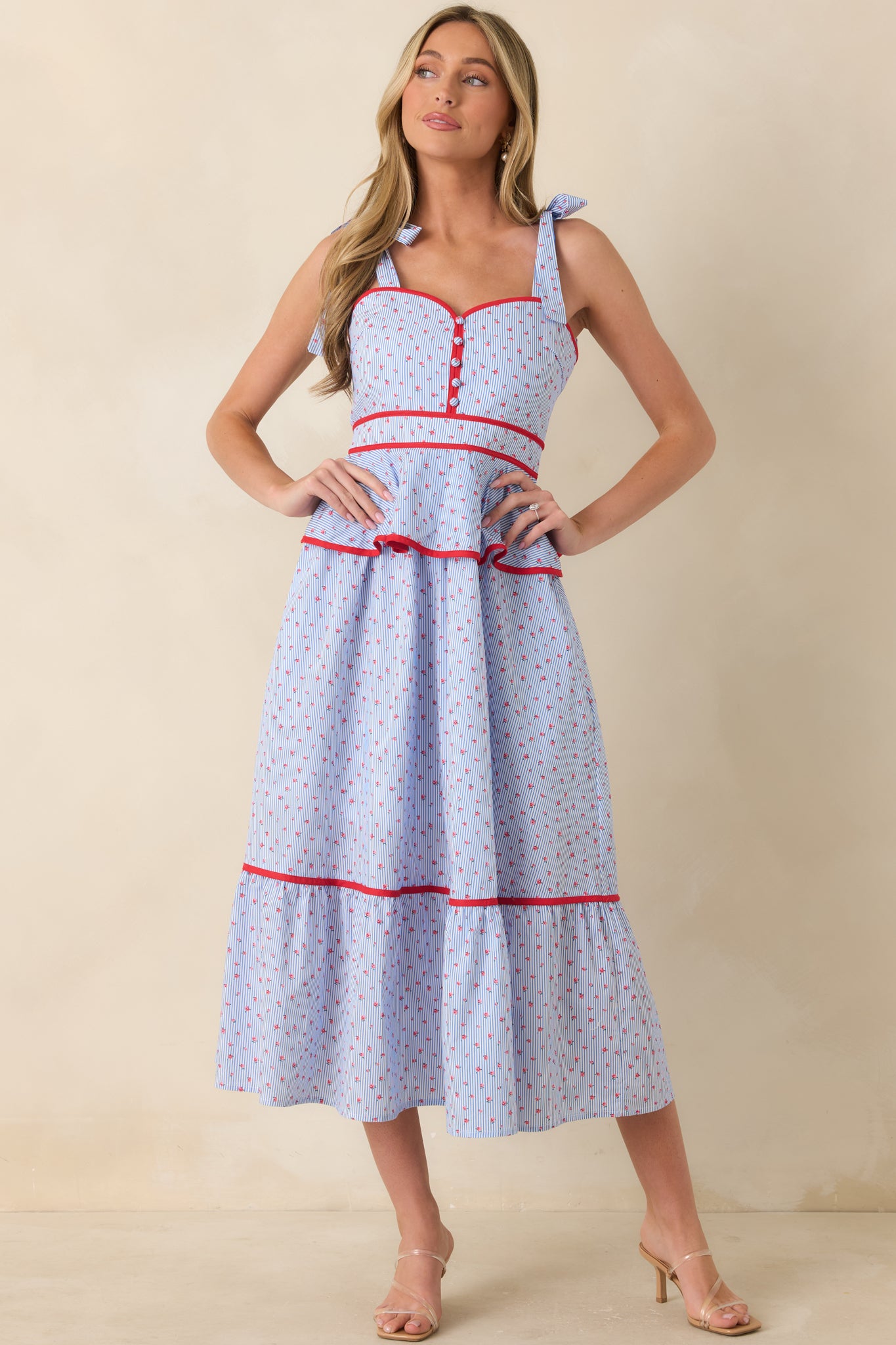 Light blue and red dress with side pockets and a fitted bodice flowing into a peplum waist.