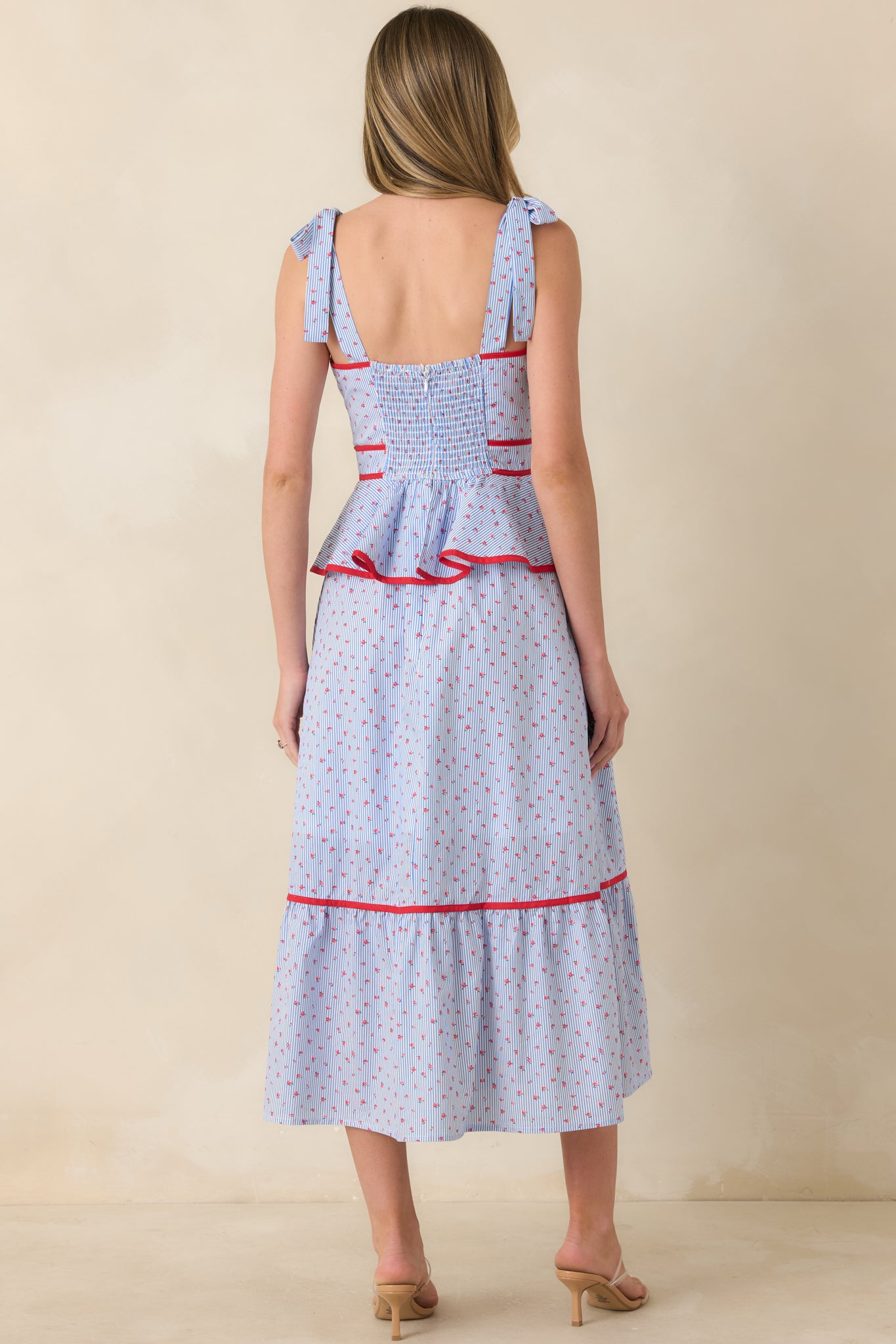 Rear view of light blue and red midi dress featuring smocked back panel and adjustable tie straps.