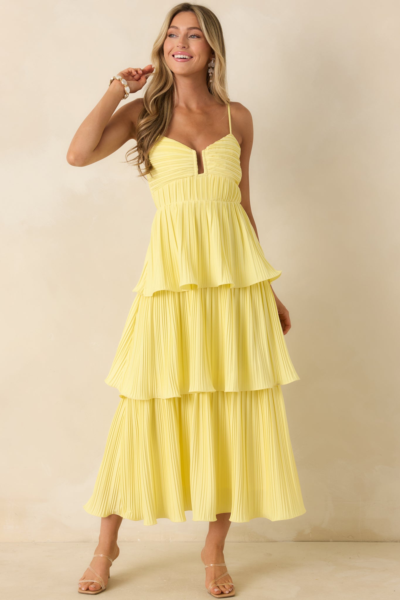 Yellow tiered dress featuring a smocked elastic back panel and an airy, flowing skirt.