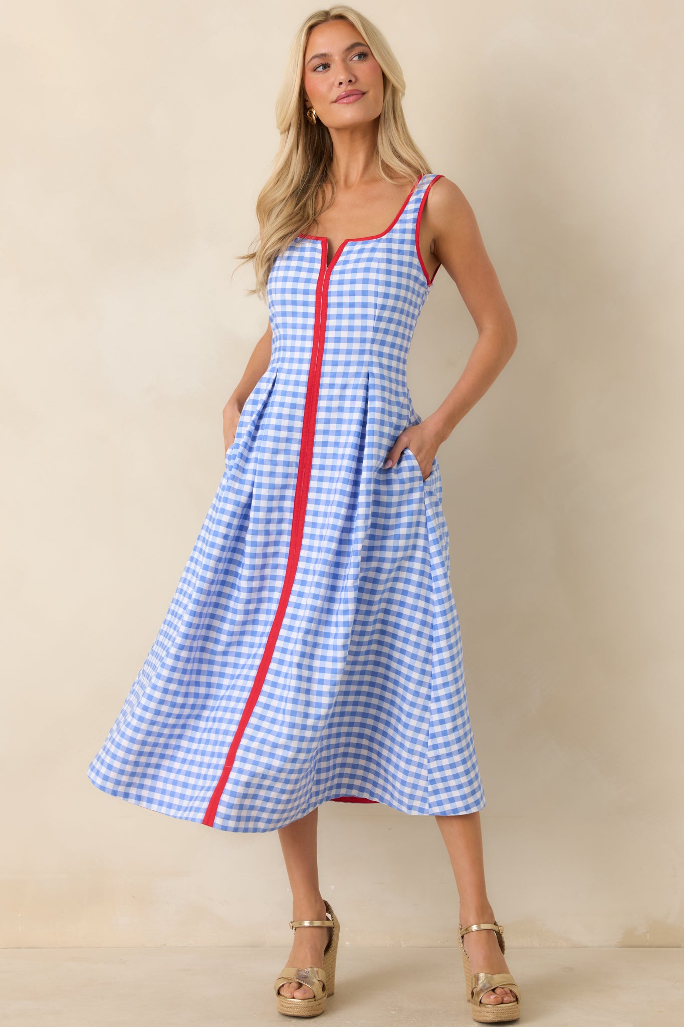 Blue gingham sleeveless dress showcasing red trim accents and a clean midi-length silhouette.