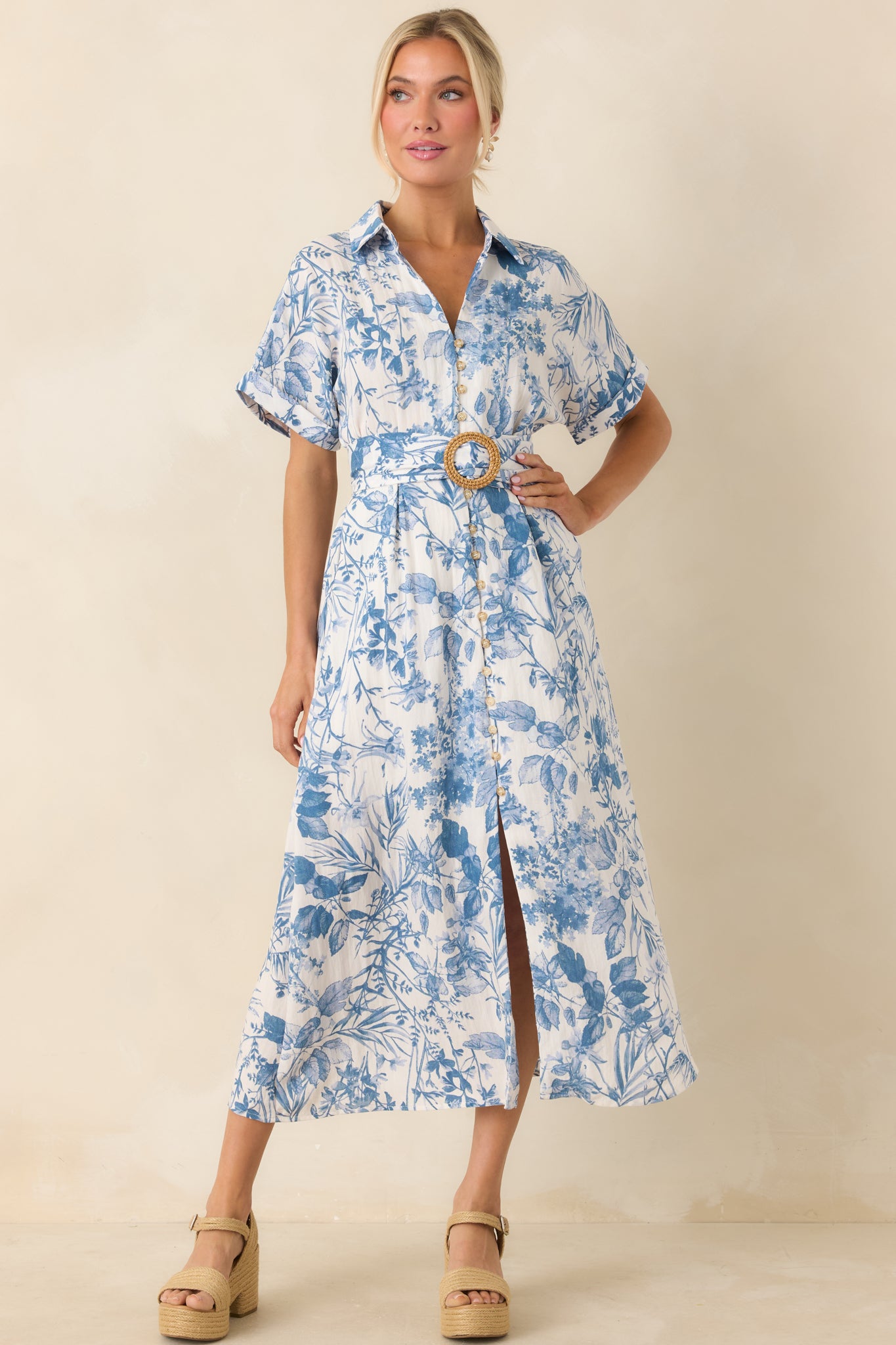 A midi dress with a collared V-neckline, functional button front, elastic waistband, pull-through belt, hip pockets, and cuffed short sleeves.