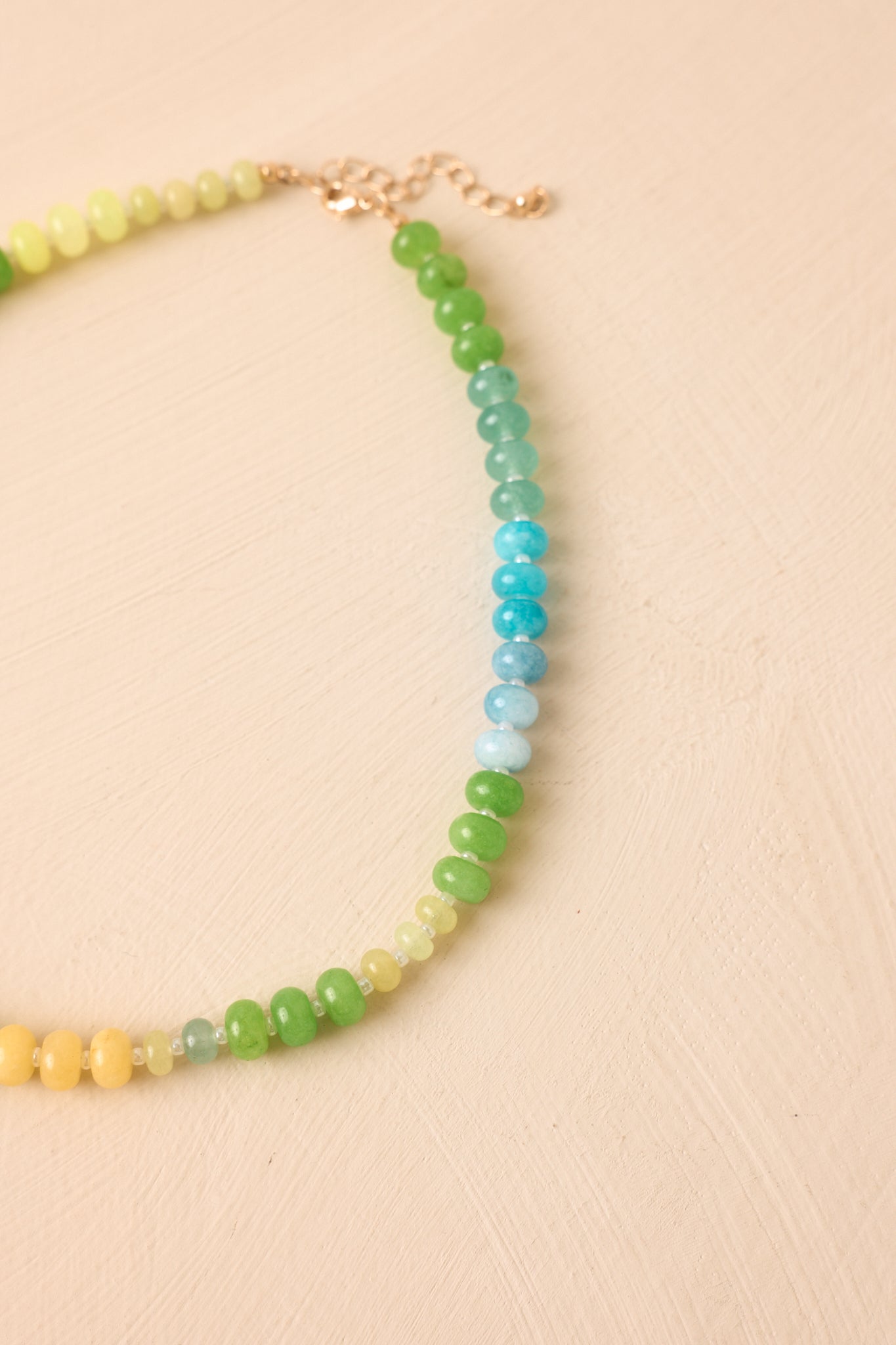 Close-up view of the beaded necklace showcasing the vibrant glass bead colors, gold-tone lobster clasp closure, and intricate details.