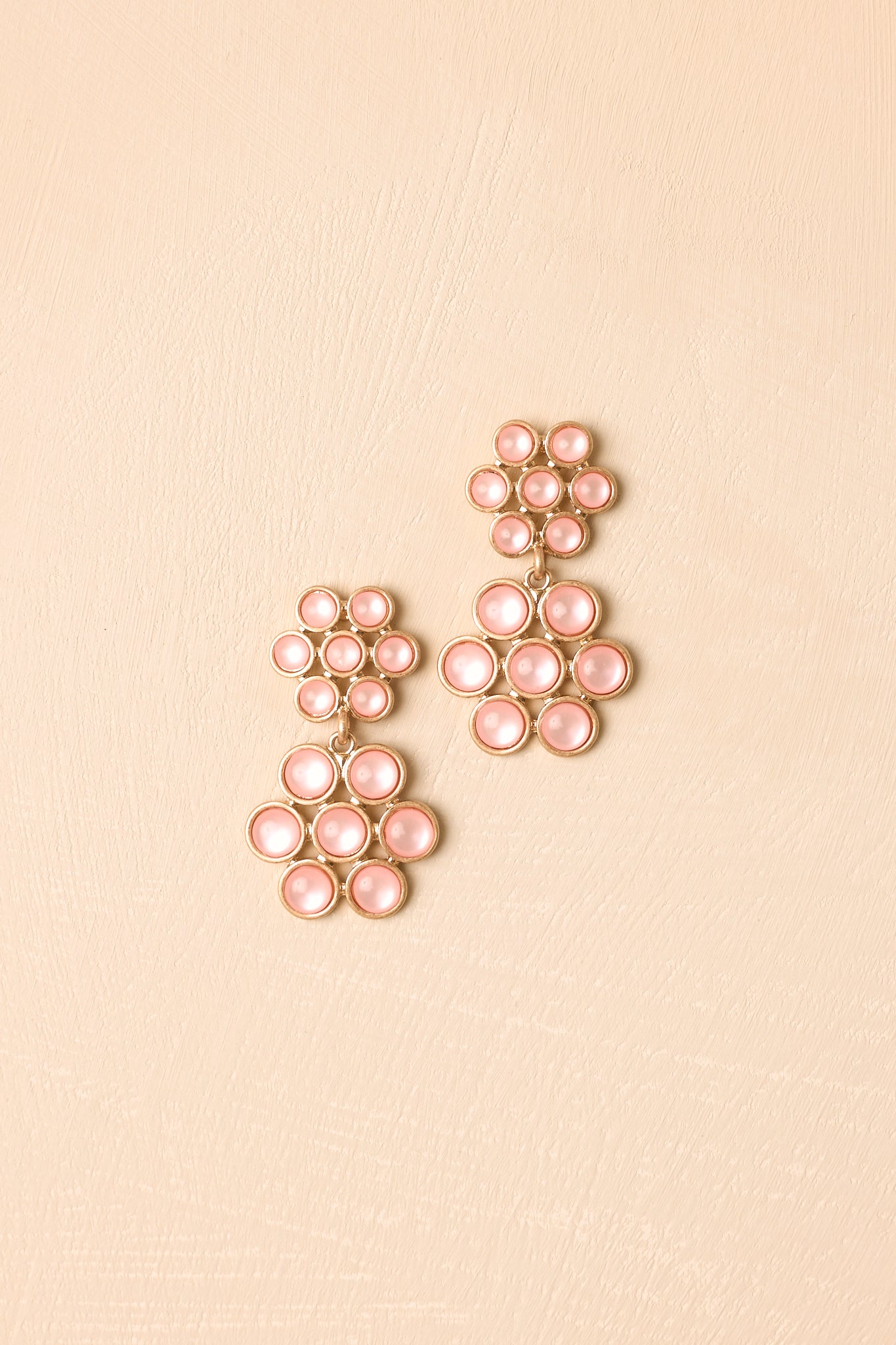 Statement flower earrings showcasing glossy soft pink surfaces, dimensional clusters, and refined metallic trim.