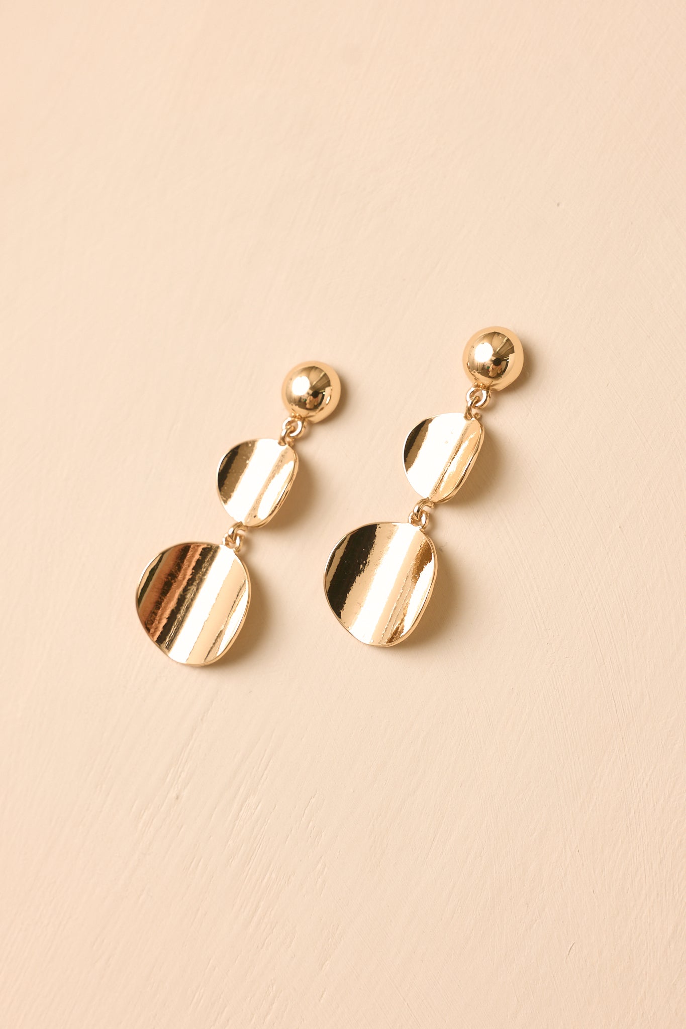 Elegant gold earrings showcasing stacked disc details, lightweight construction, and a modern polished look.