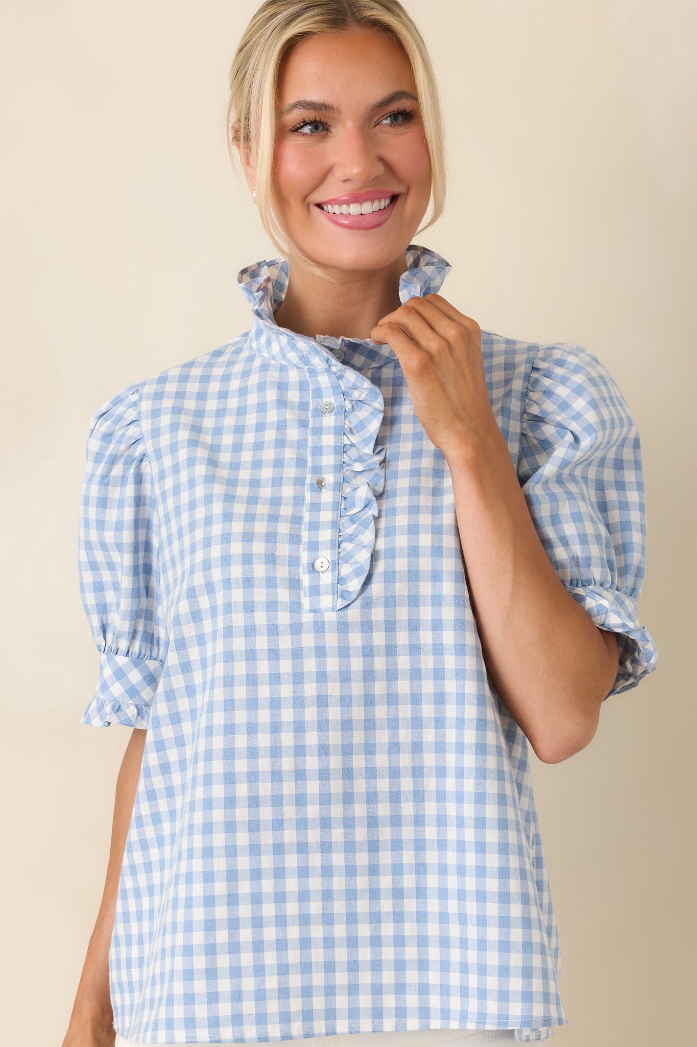 Close view of ruffled button placket with soft puff sleeve accents.
