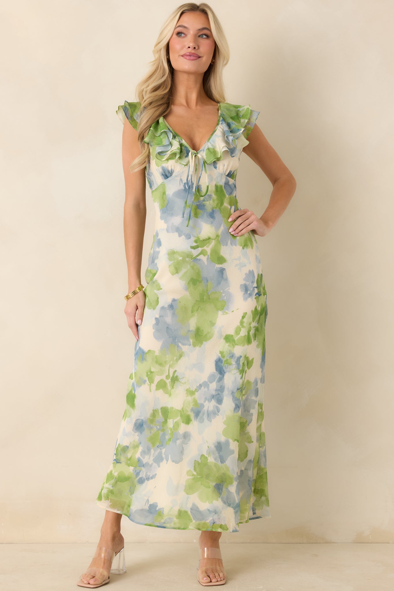 Airy floral midi dress featuring soft blue and green print, fitted bodice, and flowing skirt.
