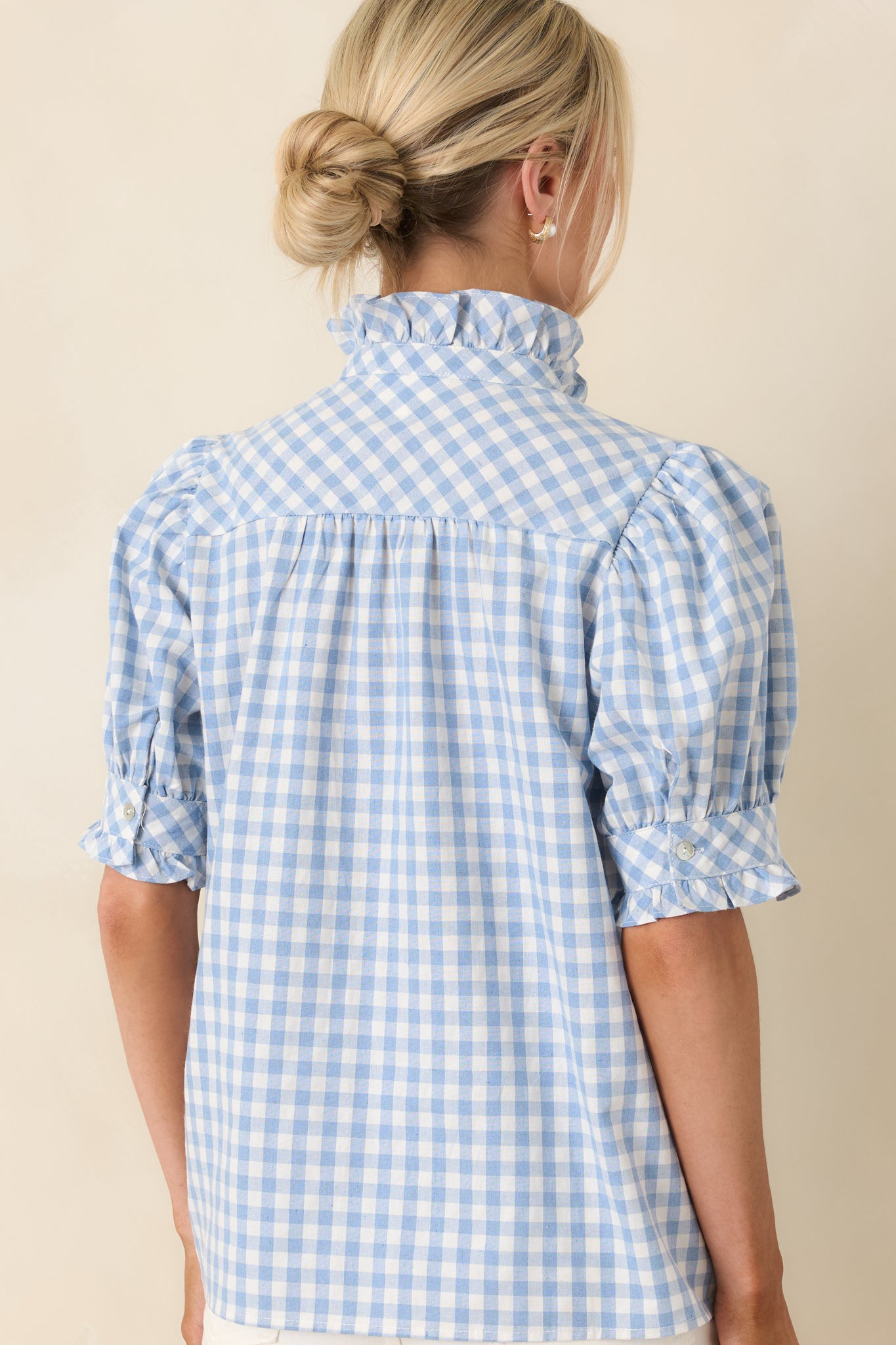 Rear view of top with puff sleeves, ruffled placket, and breezy silhouette.