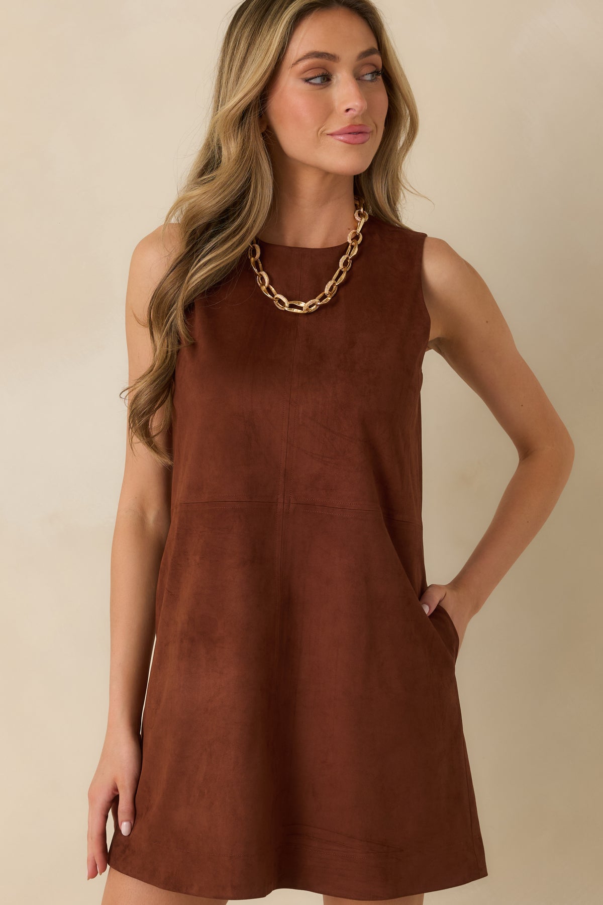 Vertical and horizontal seams add subtle definition to the brown faux suede dress.