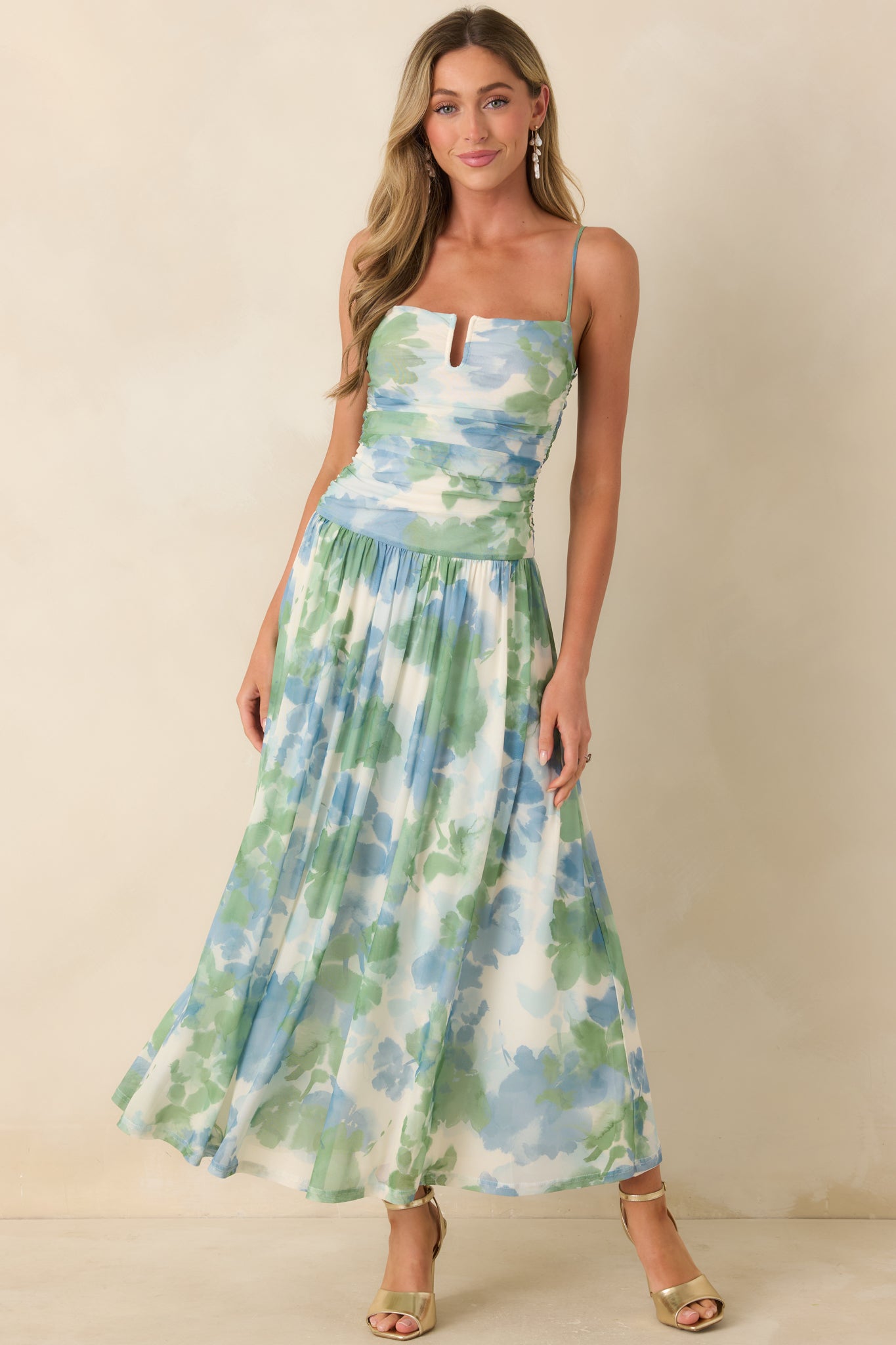 Blue and green watercolor maxi dress with ruched bodice, notch neckline, and flowing mesh skirt.
