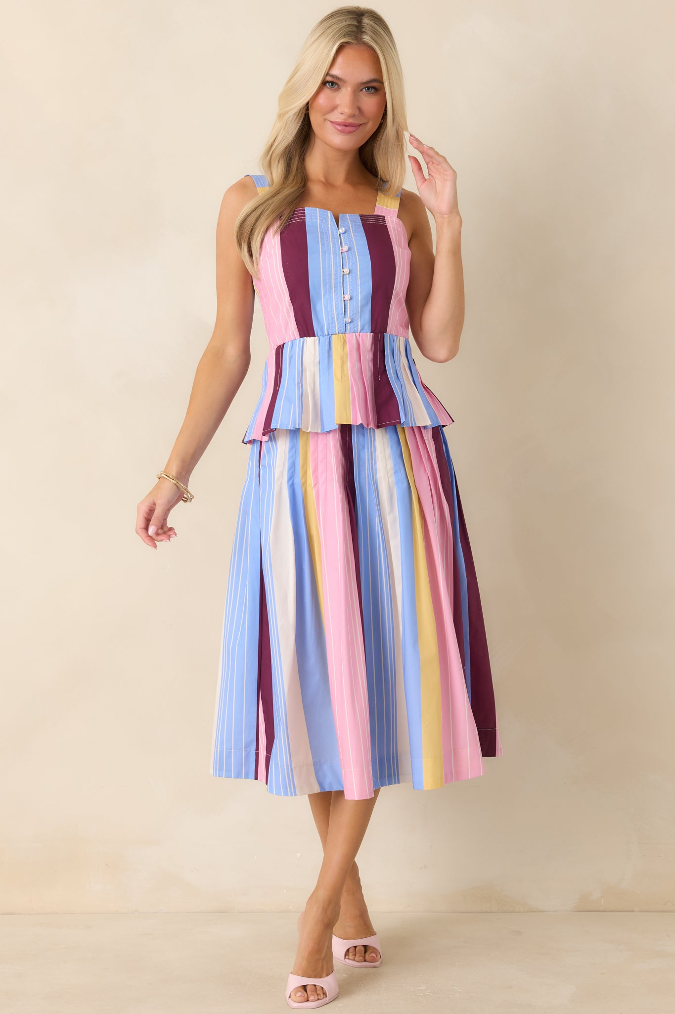 Structured button-front top with bold stripe placement and soft pleated peplum.