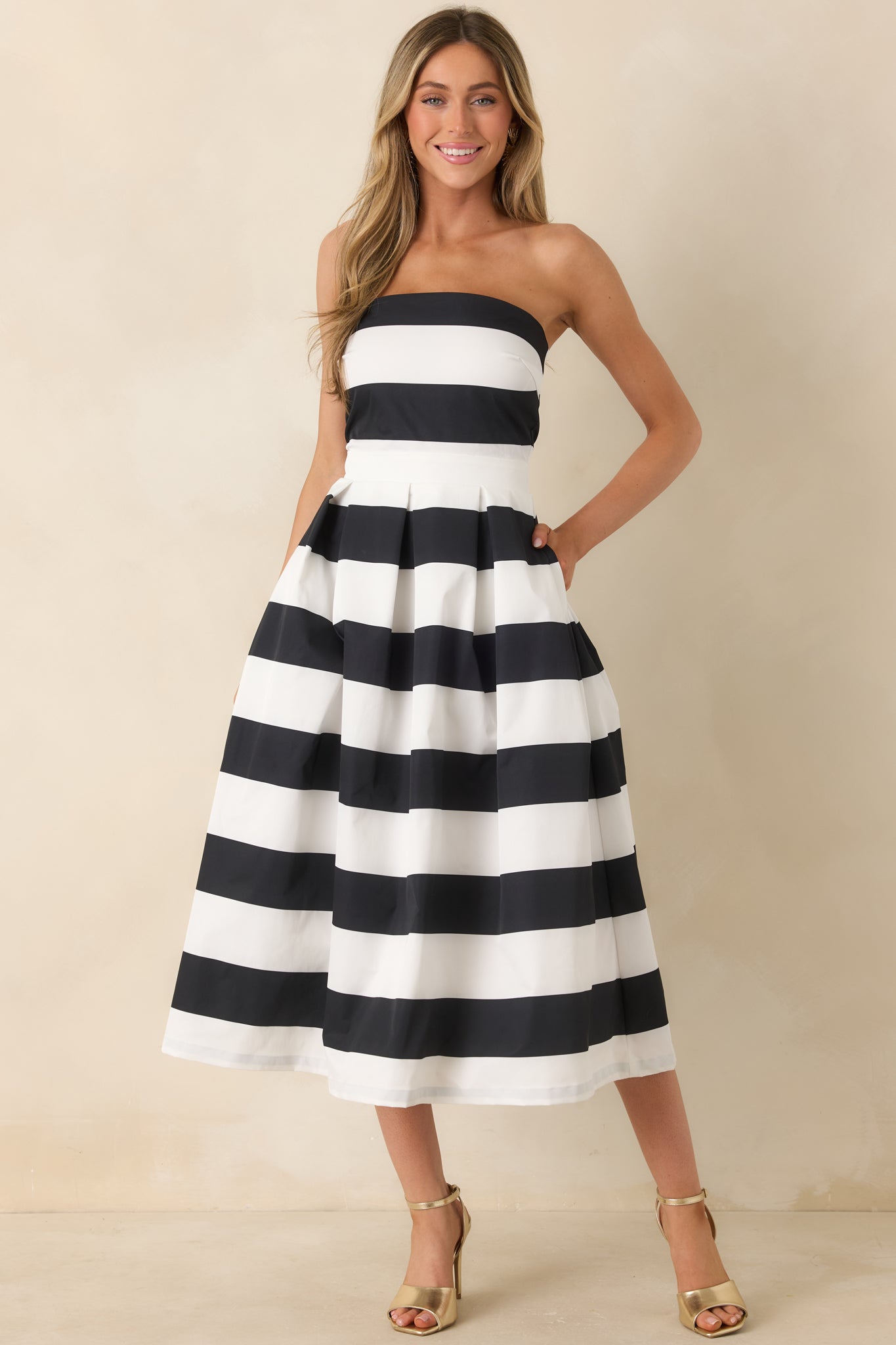Action shot of the dress capturing the flow and structure of the fabric, highlighting the strapless neckline, thick waistband, and the timeless stripe pattern.