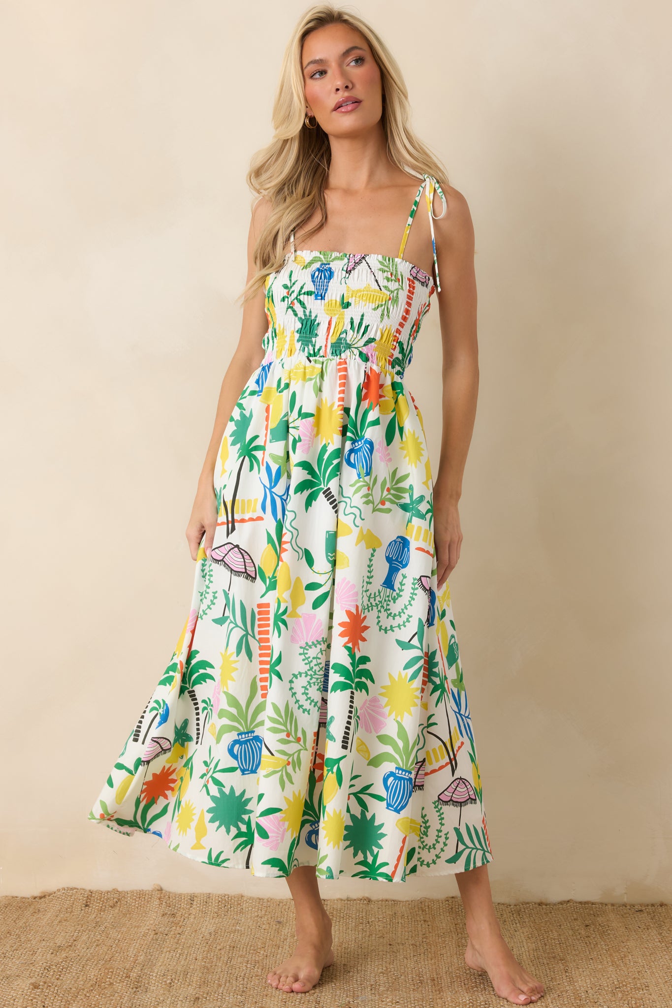 White multi cotton midi dress featuring a square neckline, smocked bodice, adjustable shoulder ties, and a flowing coastal resort print skirt.