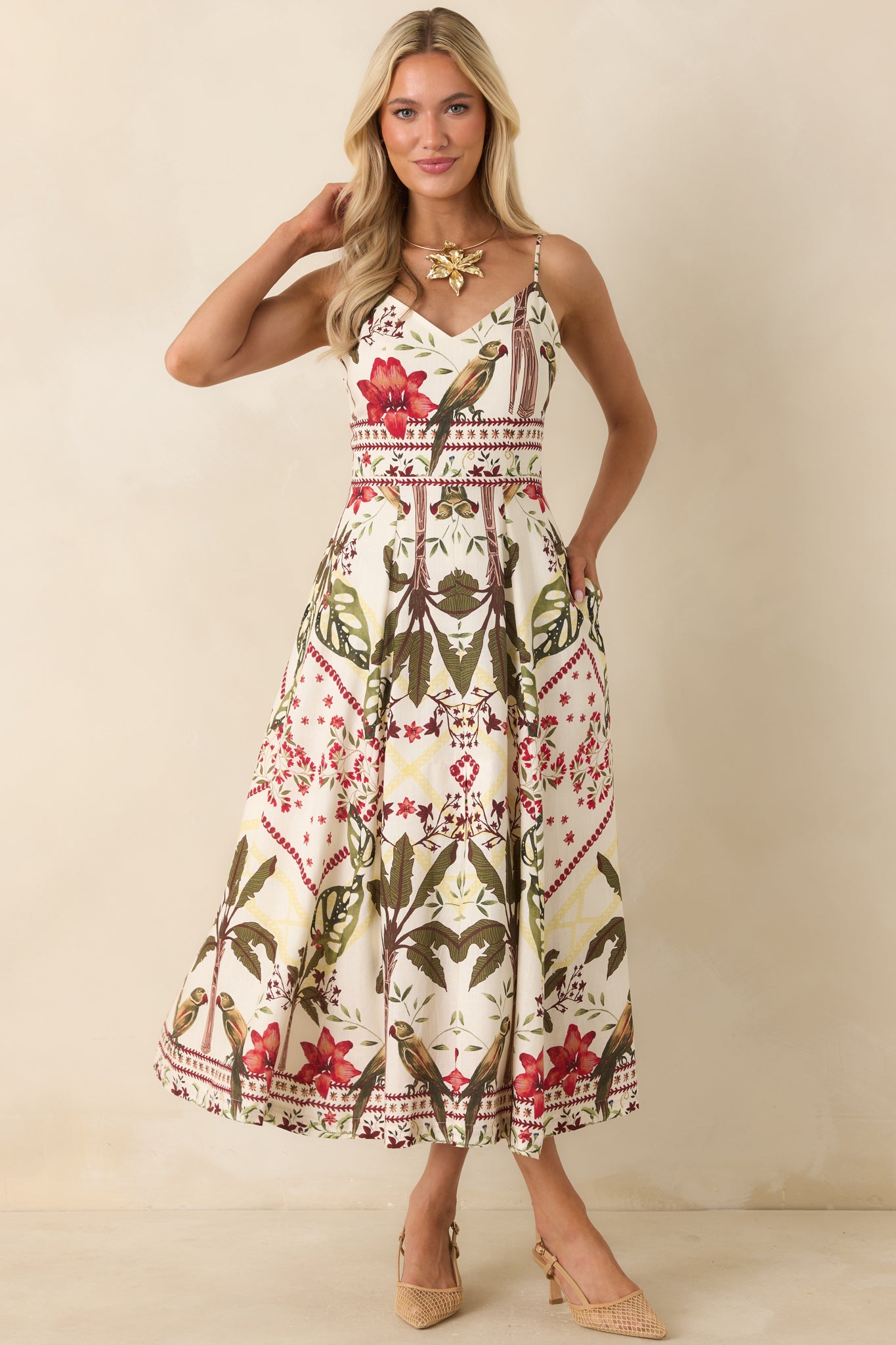 Deep red and moss green tropical print maxi dress featuring a V-neckline, adjustable spaghetti straps, and a soft linen blend fabric.