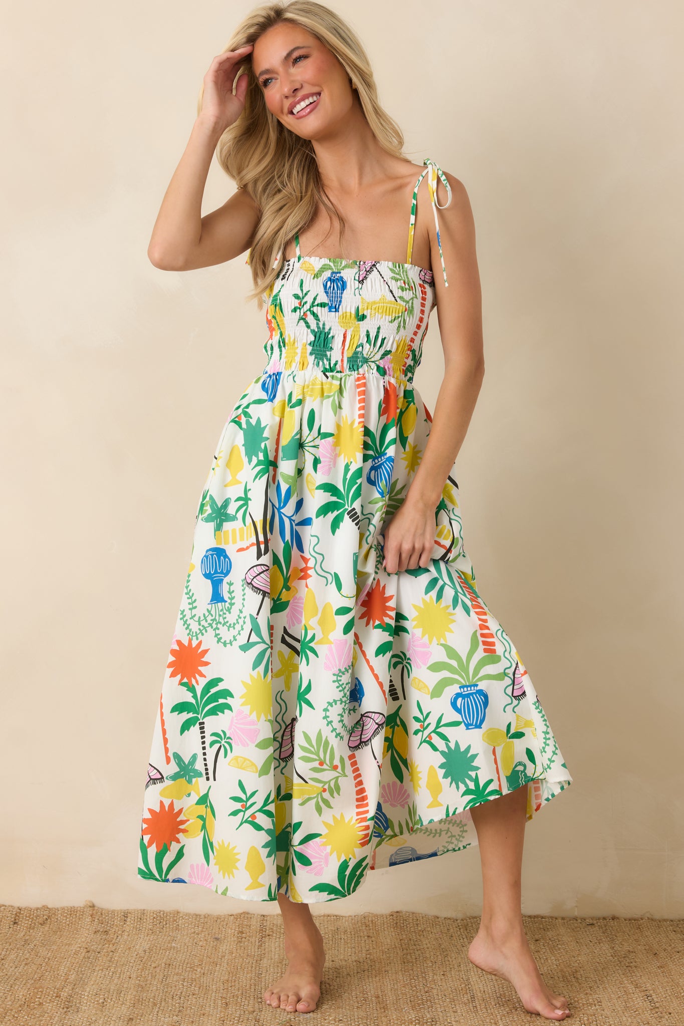 White multi cotton midi dress featuring a smocked bodice, square neckline, adjustable shoulder ties, and a full flowing skirt in a coastal resort print.