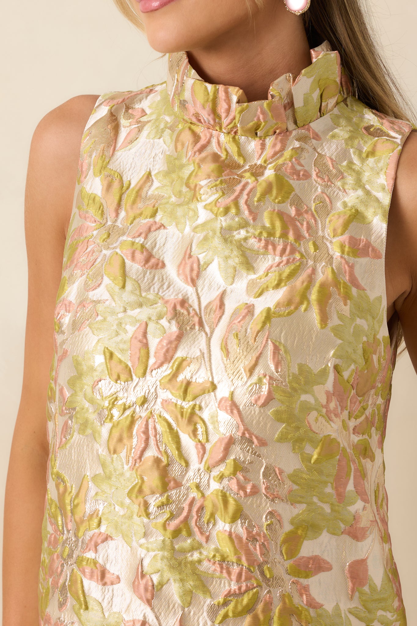Close-up detail showcasing the jacquard floral texture, metallic threads, and ruffled neckline finish.