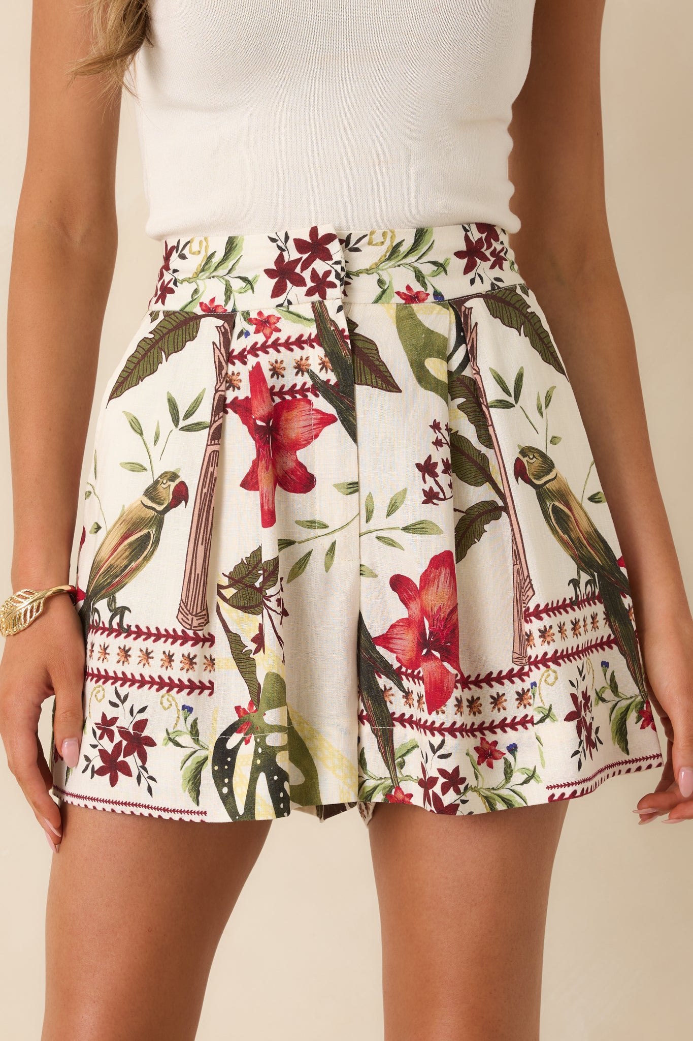 Detailed close-up of the tropical print fabric and front fastening details on the linen blend shorts.