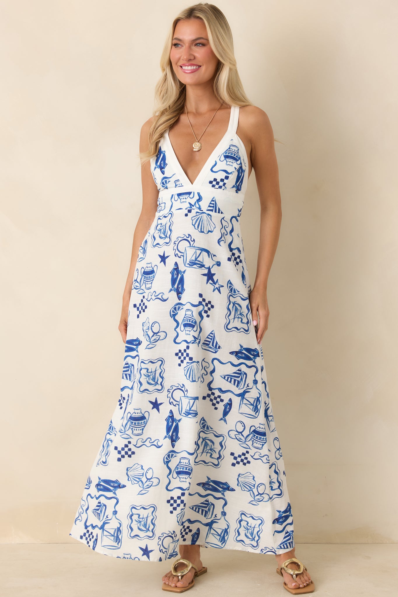 Flowy white midi dress featuring intricate blue Mediterranean-inspired motifs.