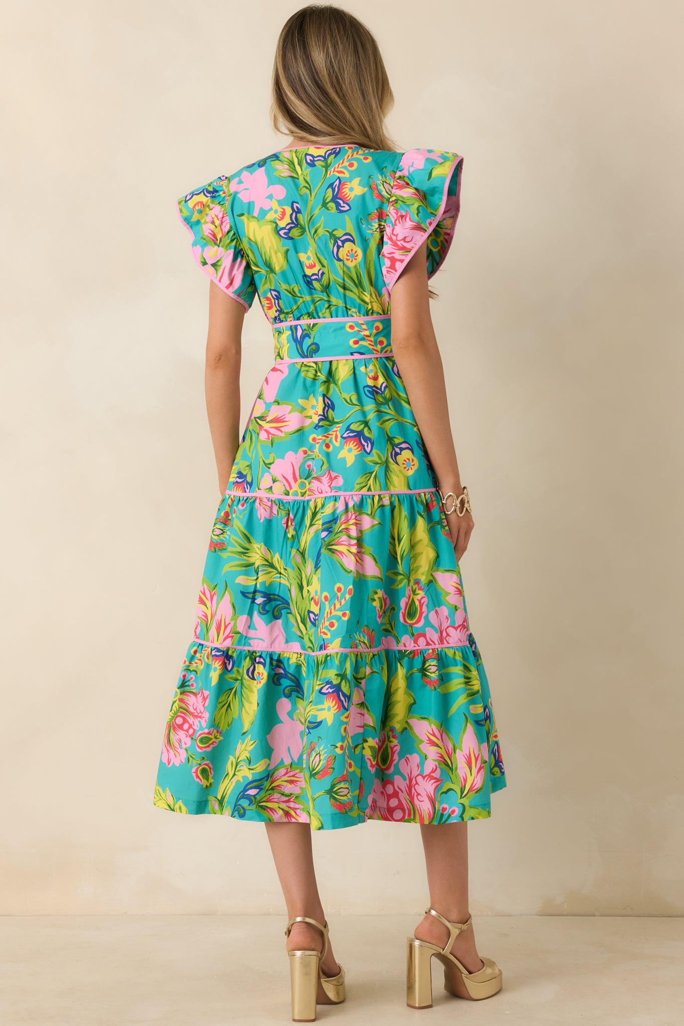 Rear view of the jade tropical floral midi dress featuring flutter sleeves, tiered skirt structure, and flowy silhouette.