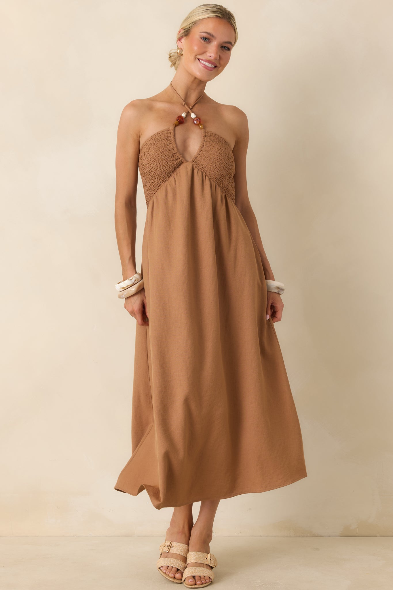 Smocked midi dress in chestnut brown featuring a halter tie neckline and naturally gathered waist shaping.