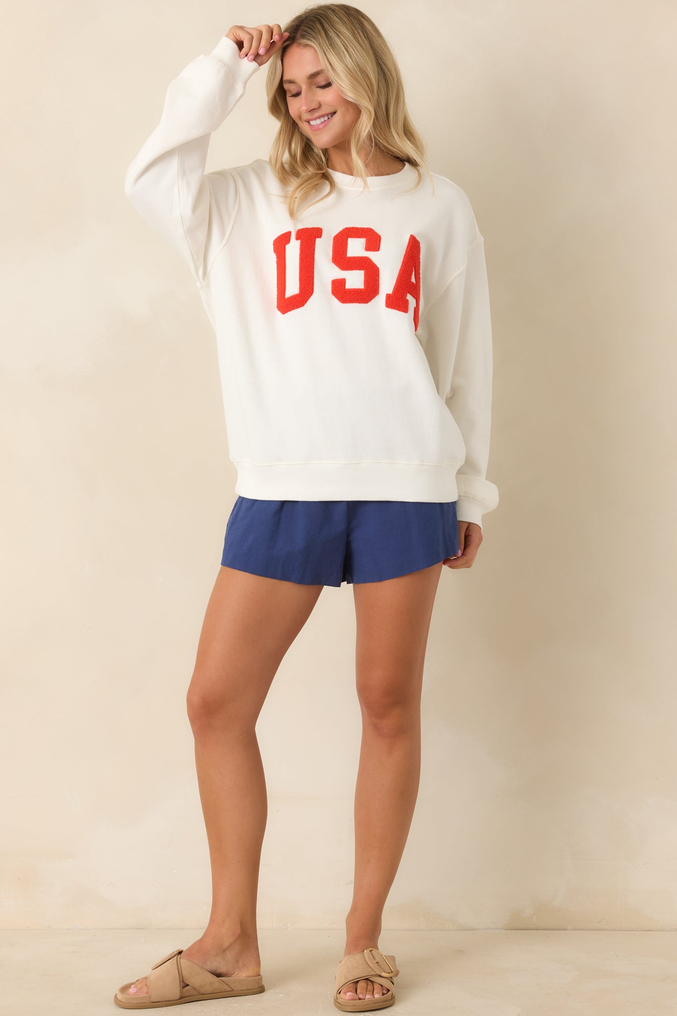 Front view highlighting the slightly oversized drape, lightweight cotton feel, and raised “USA” lettering across a clean ivory base.