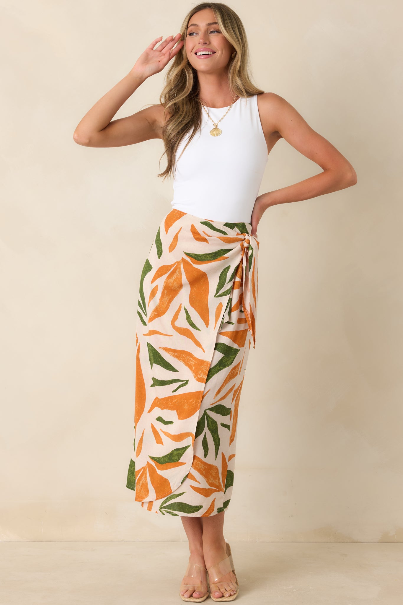 High-waisted tropical midi skirt with vibrant orange and green print and lightweight drape.