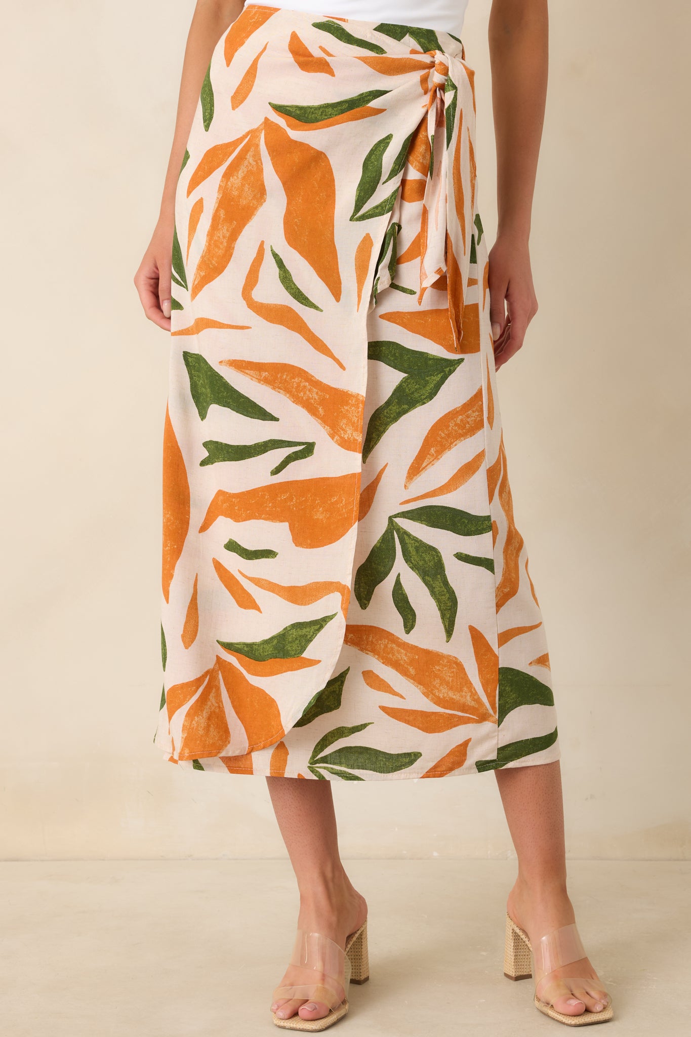 Tropical print skirt detail highlighting self-tie wrap feature and high-waisted fit.