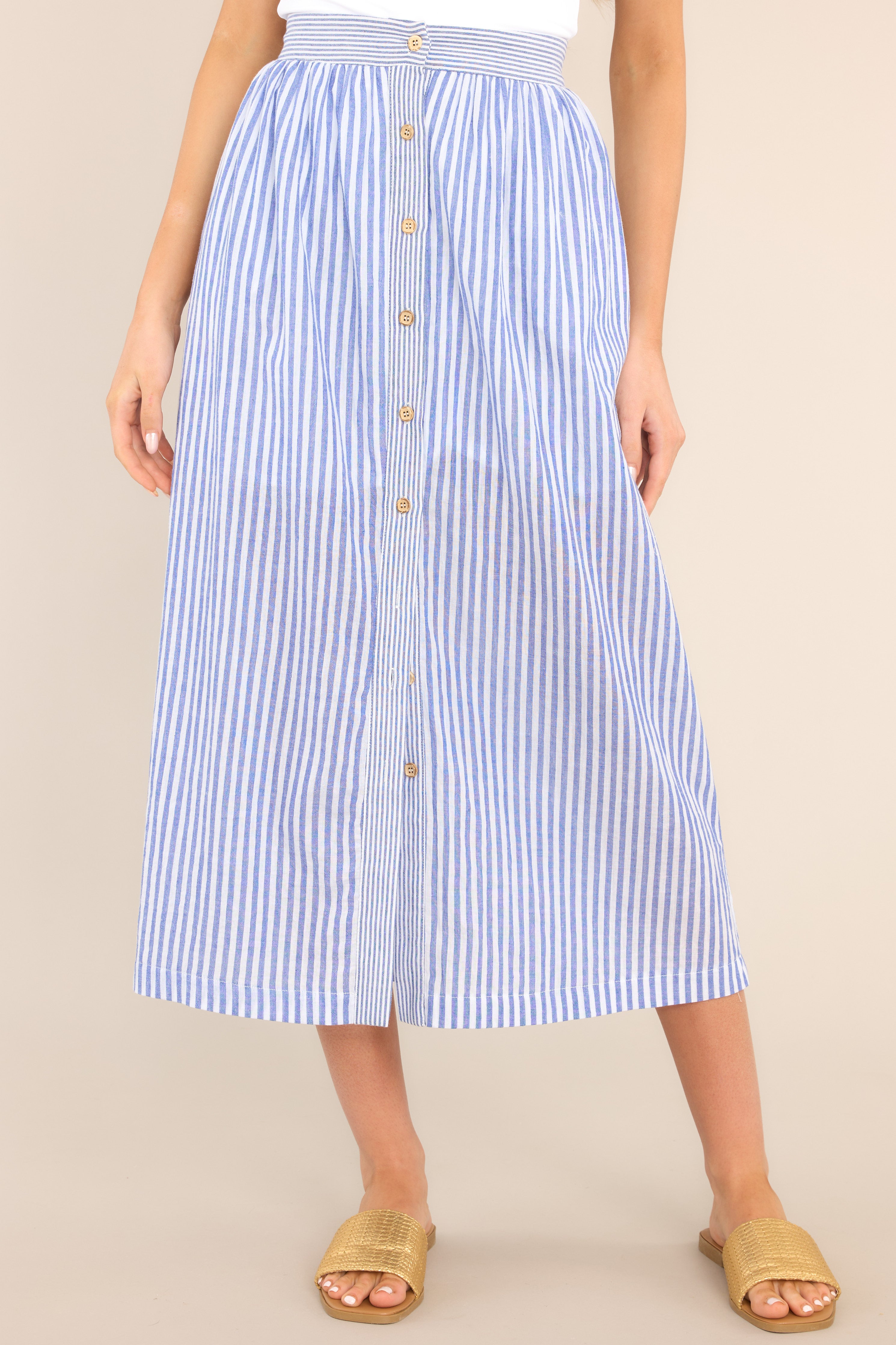 Front view of this skirt that features a fully functional button front, fully functional pockets at the hips, an elastic waist band at the back, and a straightened silhouette.