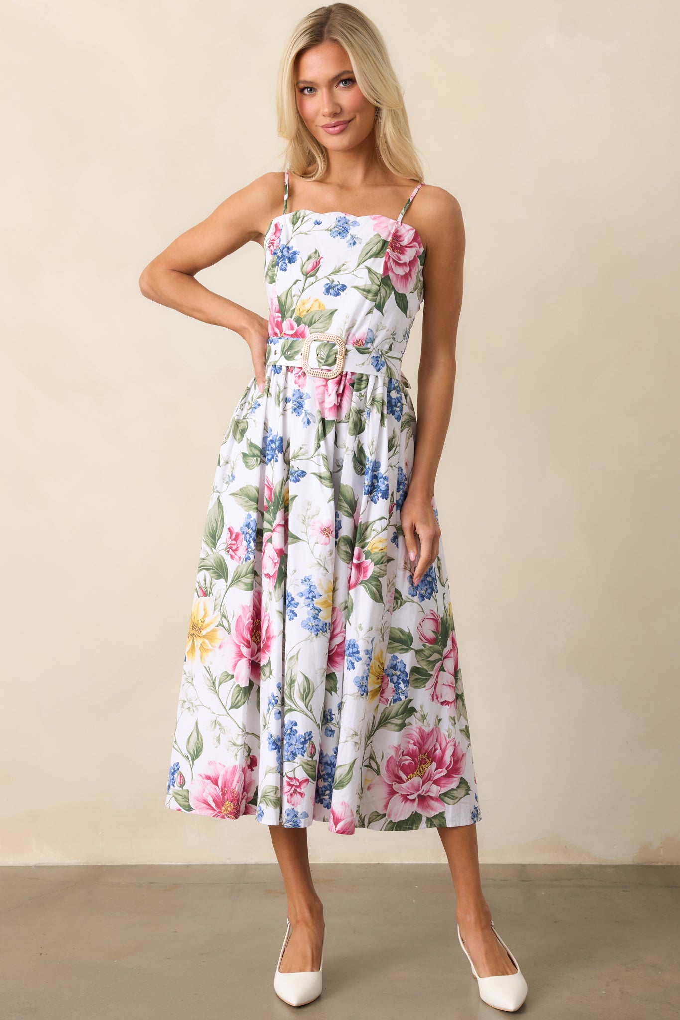 A breezy midi dress showcasing a scalloped neckline, colorful floral print, and adjustable straps for a customizable fit.