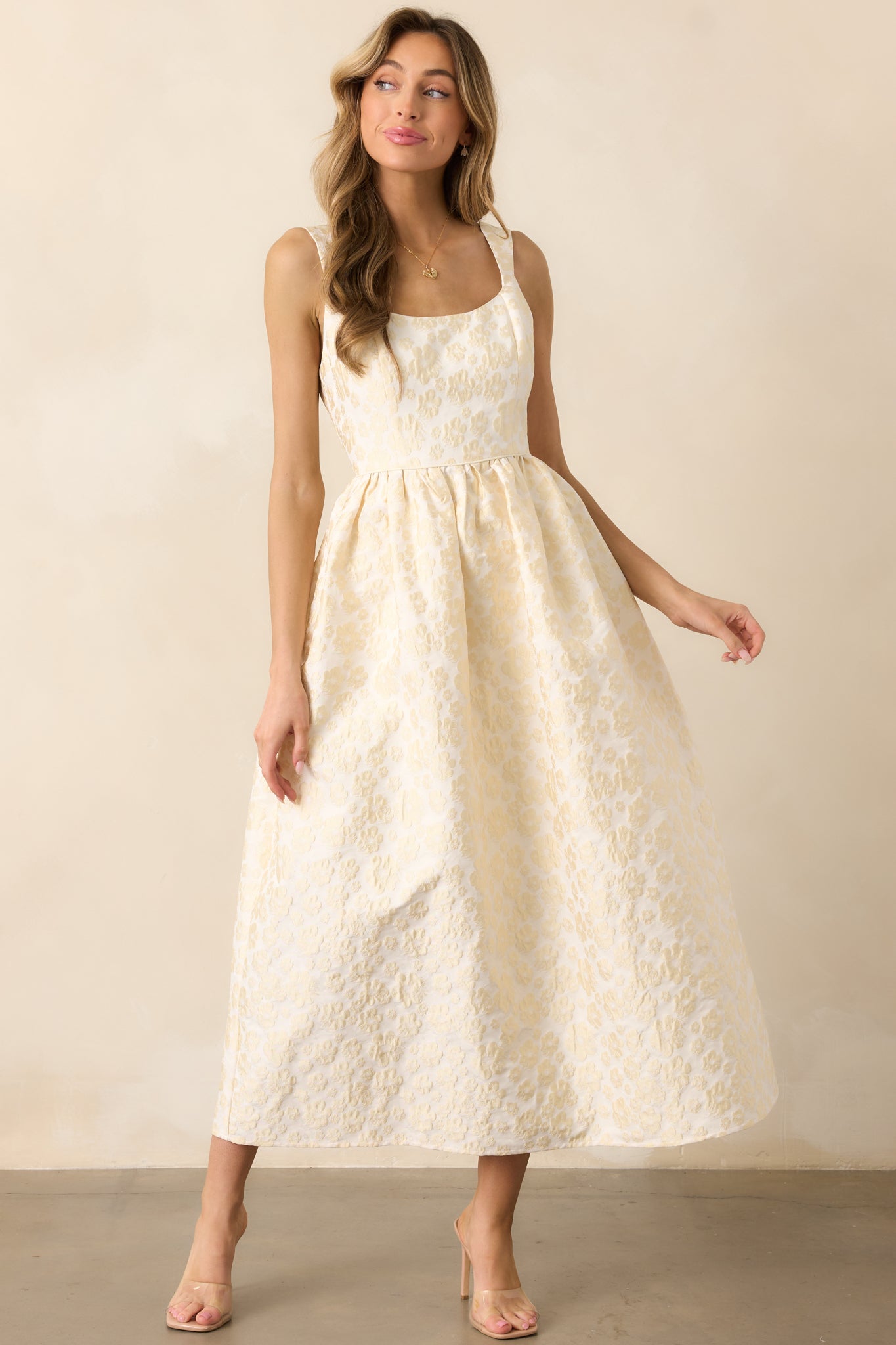 A sophisticated butter yellow dress with a delicate floral jacquard pattern, a sleeveless cut, and a classic fit-and-flare silhouette.