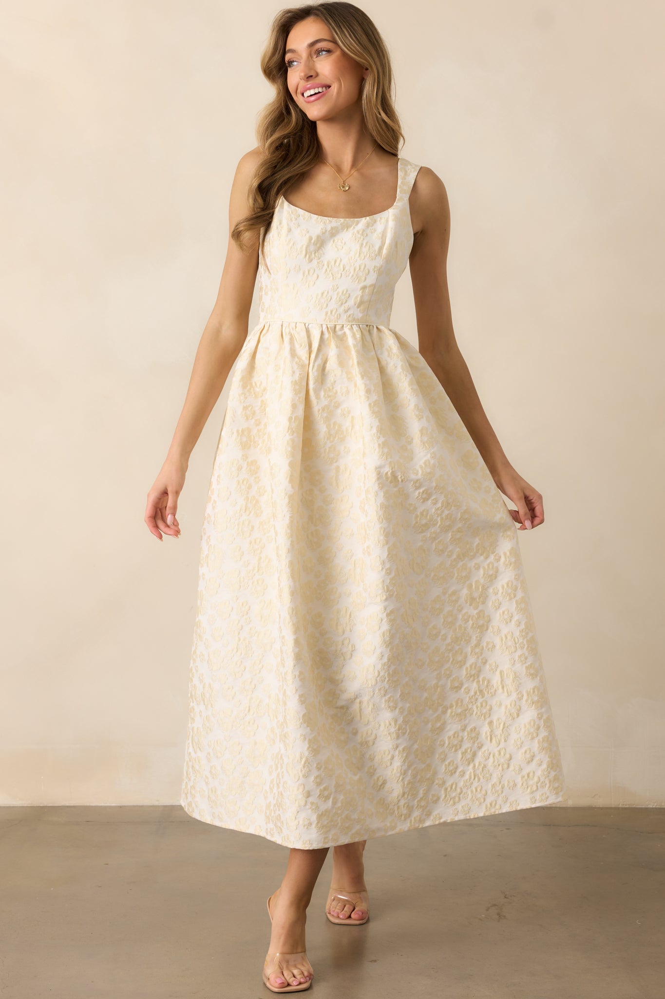 A sleeveless butter yellow dress with a fitted bodice, a floral jacquard texture, and a voluminous structured skirt.