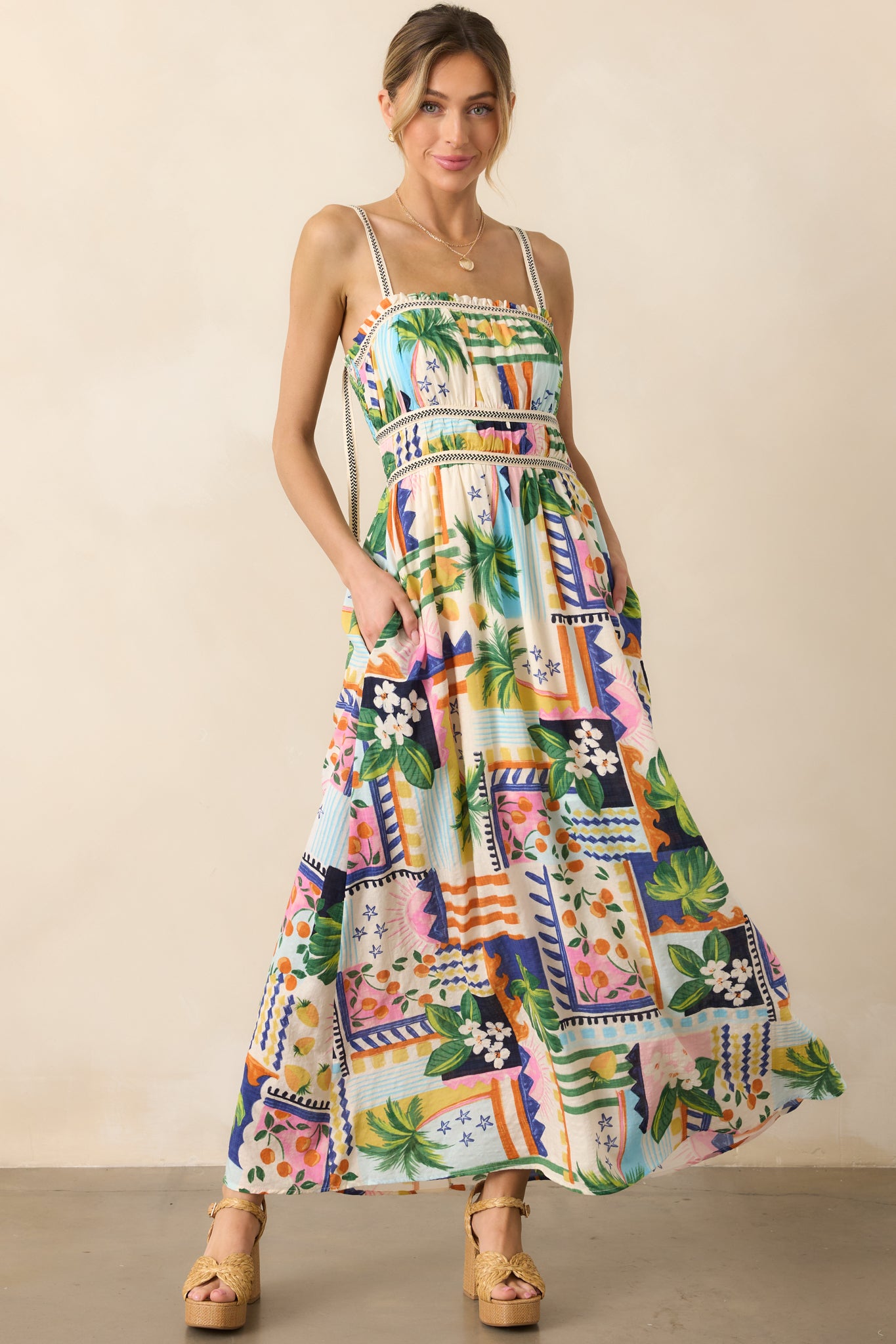 Another angled front view of the dress, showcasing its ruffled square neckline, tropical pattern, and flowing silhouette.