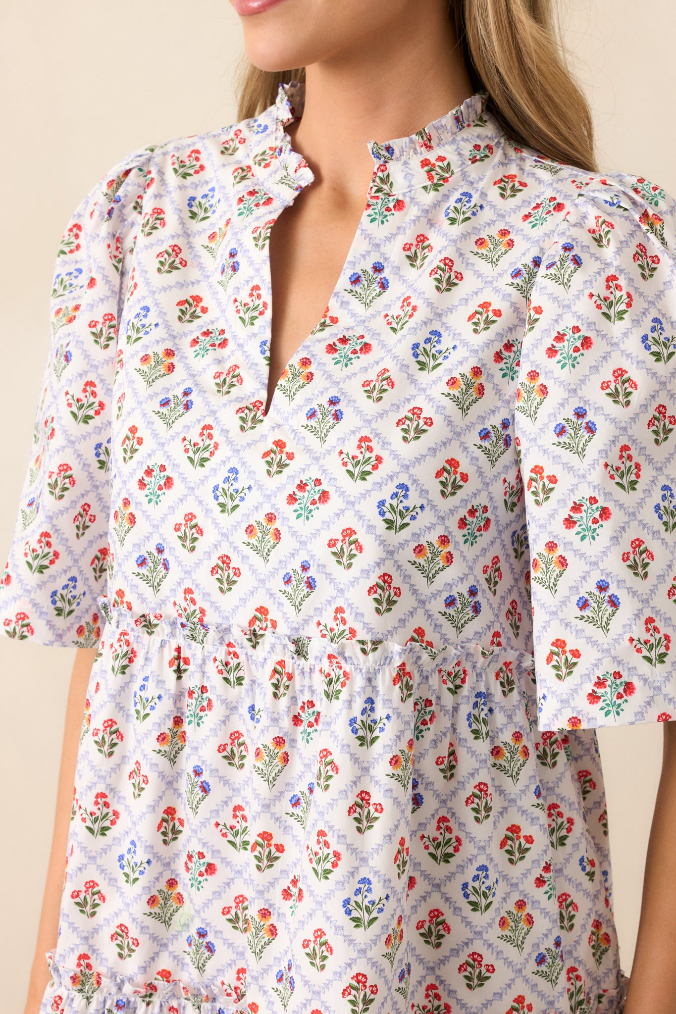 A zoomed-in view of the functional pockets on the mini dress, featuring the criss-cross grid pattern and floral motifs.