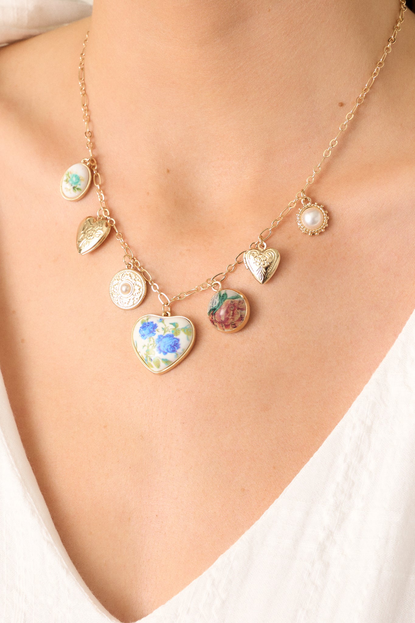 A zoomed-in shot highlighting the fine details of a floral locket on the gold necklace, emphasizing its craftsmanship and texture.
