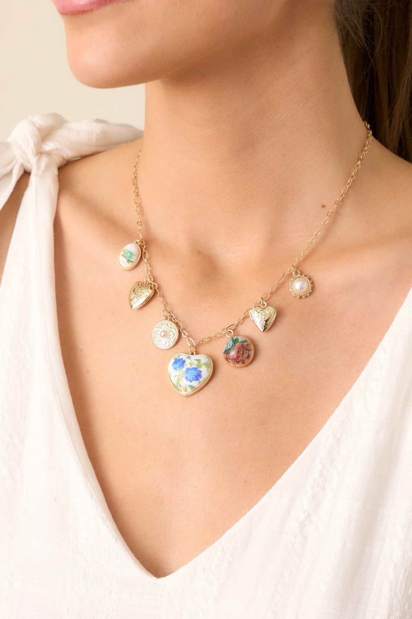 A close view of the gold necklace, showcasing the intricate floral charms and their balanced placement along the chain.