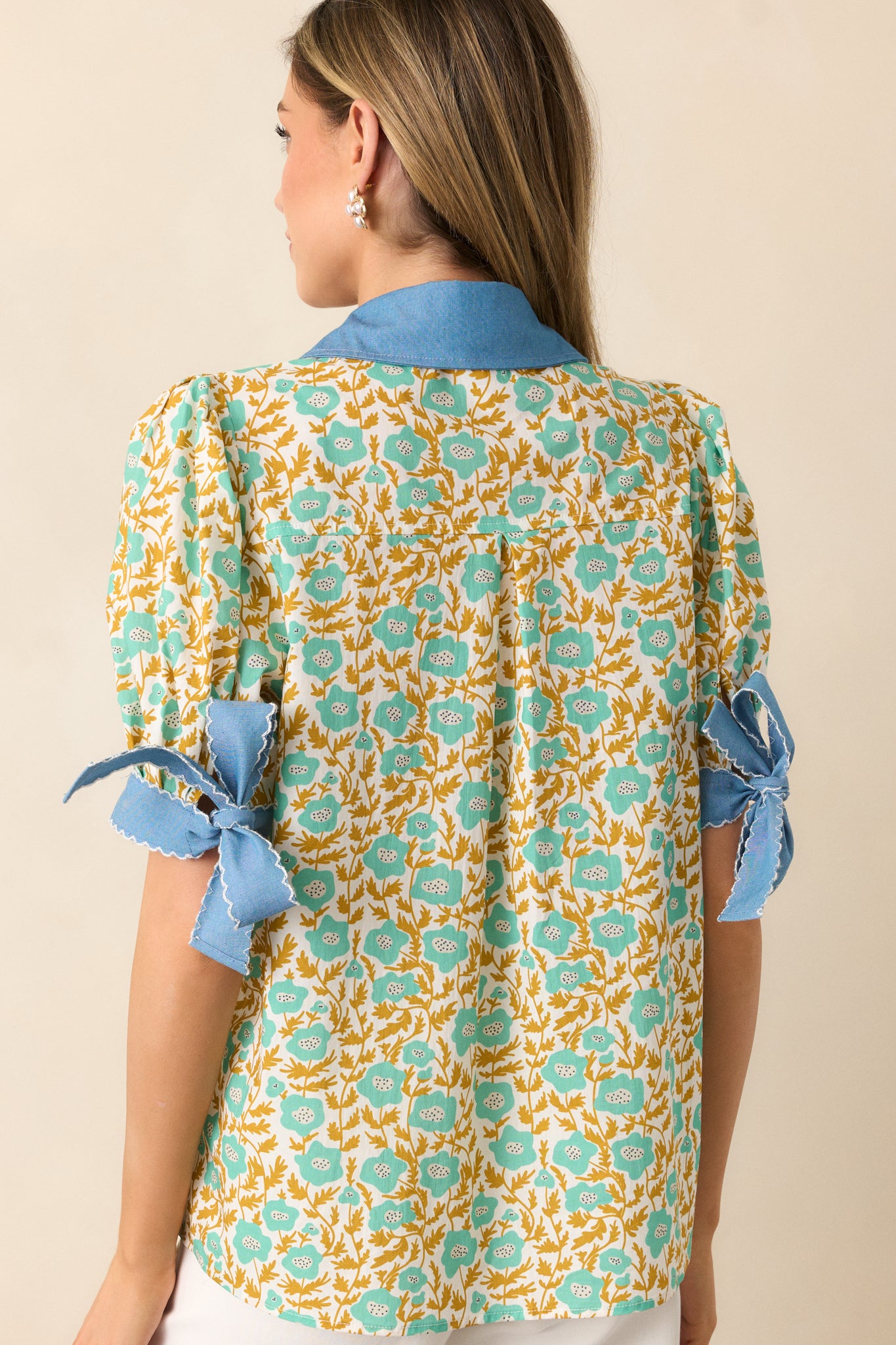 The floral print flows seamlessly across the rear, highlighting the embroidered scallop hem and denim-trimmed accents.