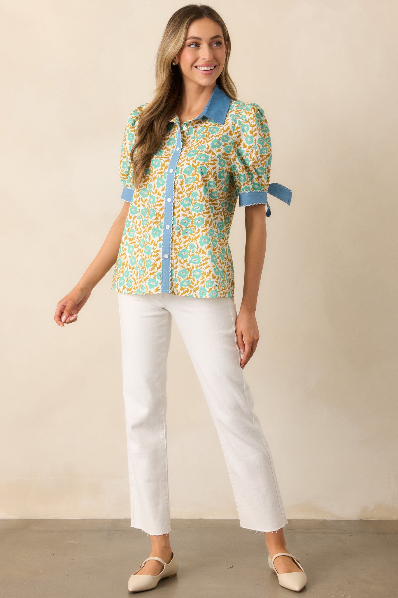 A charming floral blouse featuring short puff sleeves, self-tie bow cuffs, and embroidered scallop hem detailing.