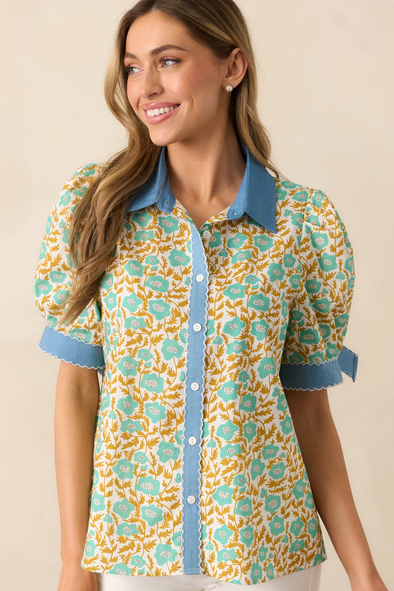 Green floral top with a collared neckline, functional button front, and blue denim trim for a unique contrast.
