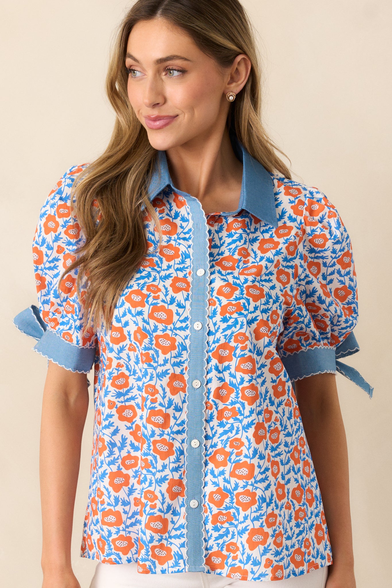 A full view of the top, showcasing the short puff sleeves with self-tie bow cuffs and the embroidered scallop hem detailing.