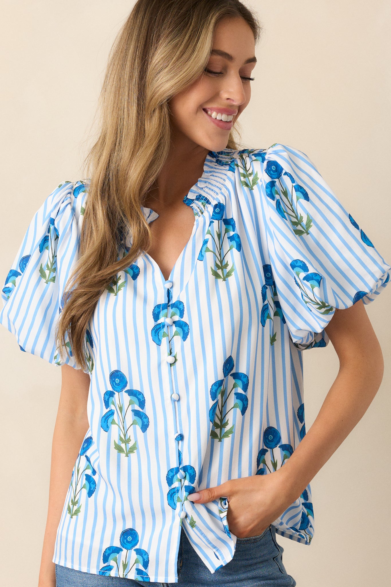 Close-up of the ruffle v-neckline and button front design, highlighting the soft fabric and intricate poppy flower pattern.