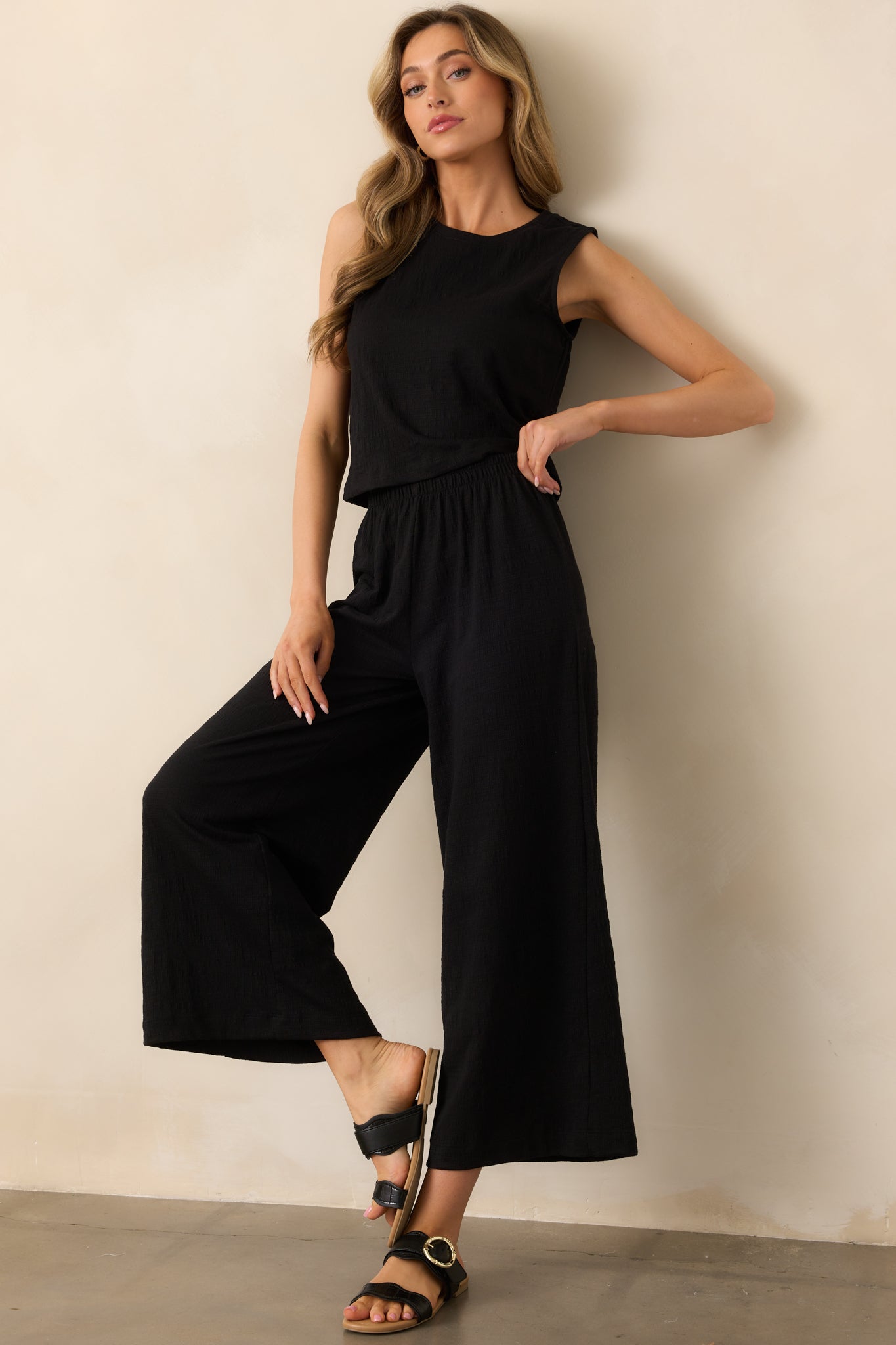Black ankle-length pants with a textured fabric and a comfortable elastic waistband.