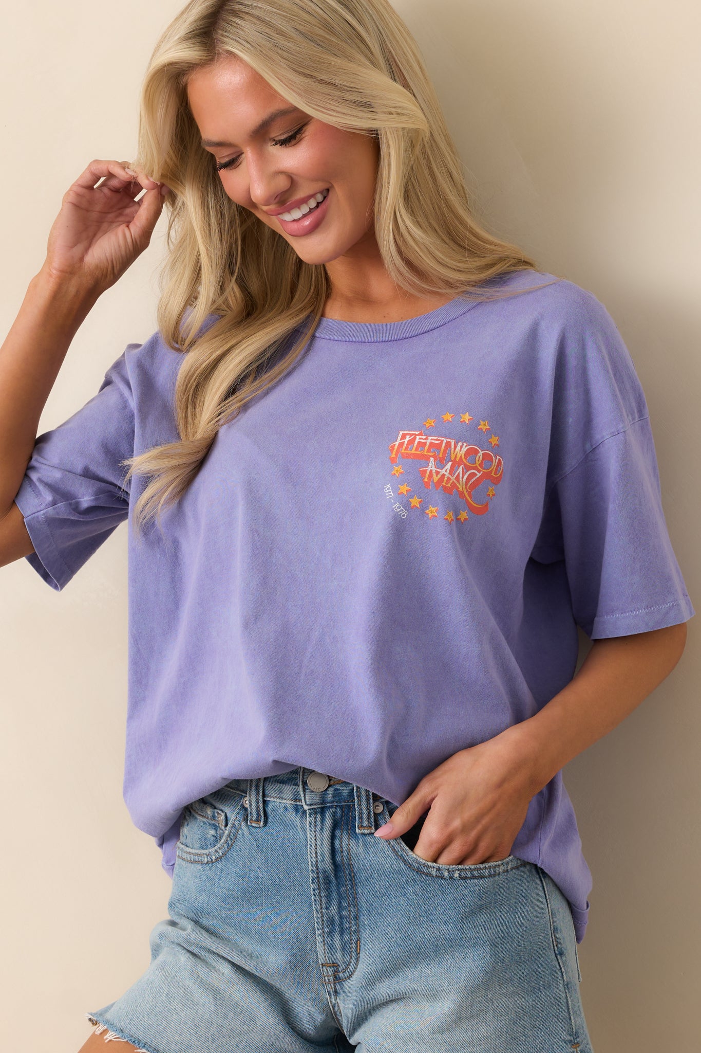 Cropped view focusing on the left chest area showing the stamped Fleetwood Mac logo on the purple tee.