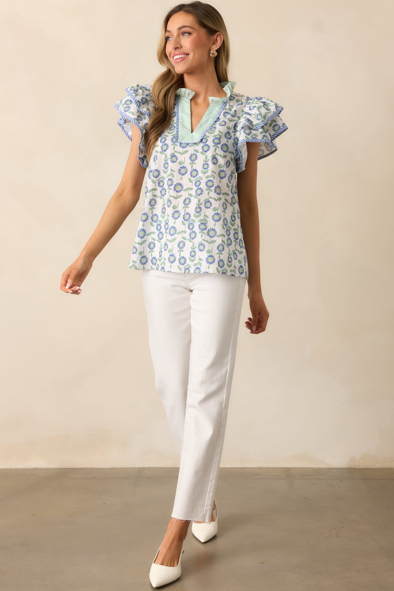 A lightweight floral top with a ruffled notch V-neckline, striped trim accents, and fluttery layered sleeves for a feminine touch.