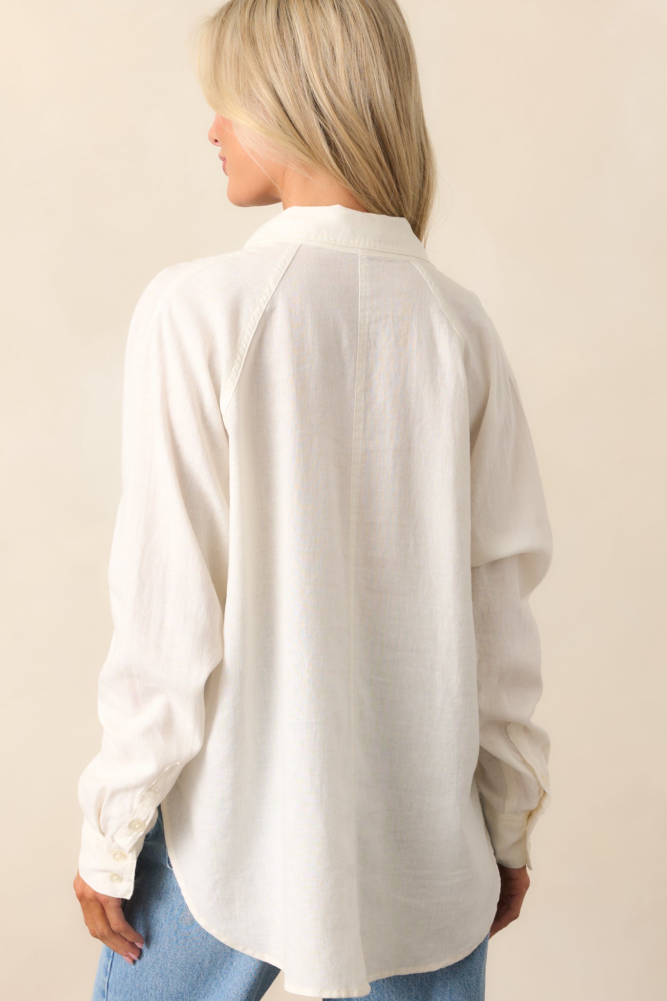 The white top viewed from behind, showcasing the split high-low hemline and relaxed fit.