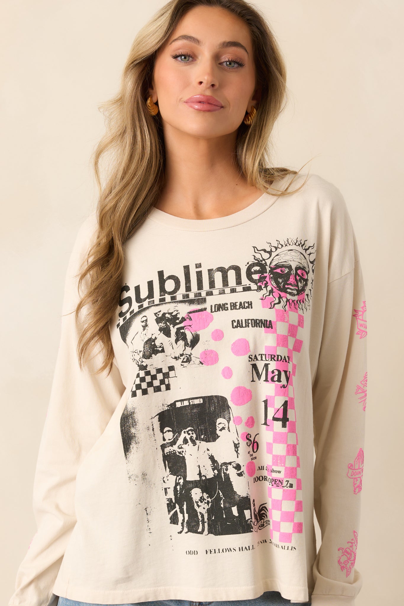 A detailed view of the white tee highlights Sublime track names and black-and-white band photos, with a bold checkered pink puff ink print and the ribbed cuffs of the long sleeves.