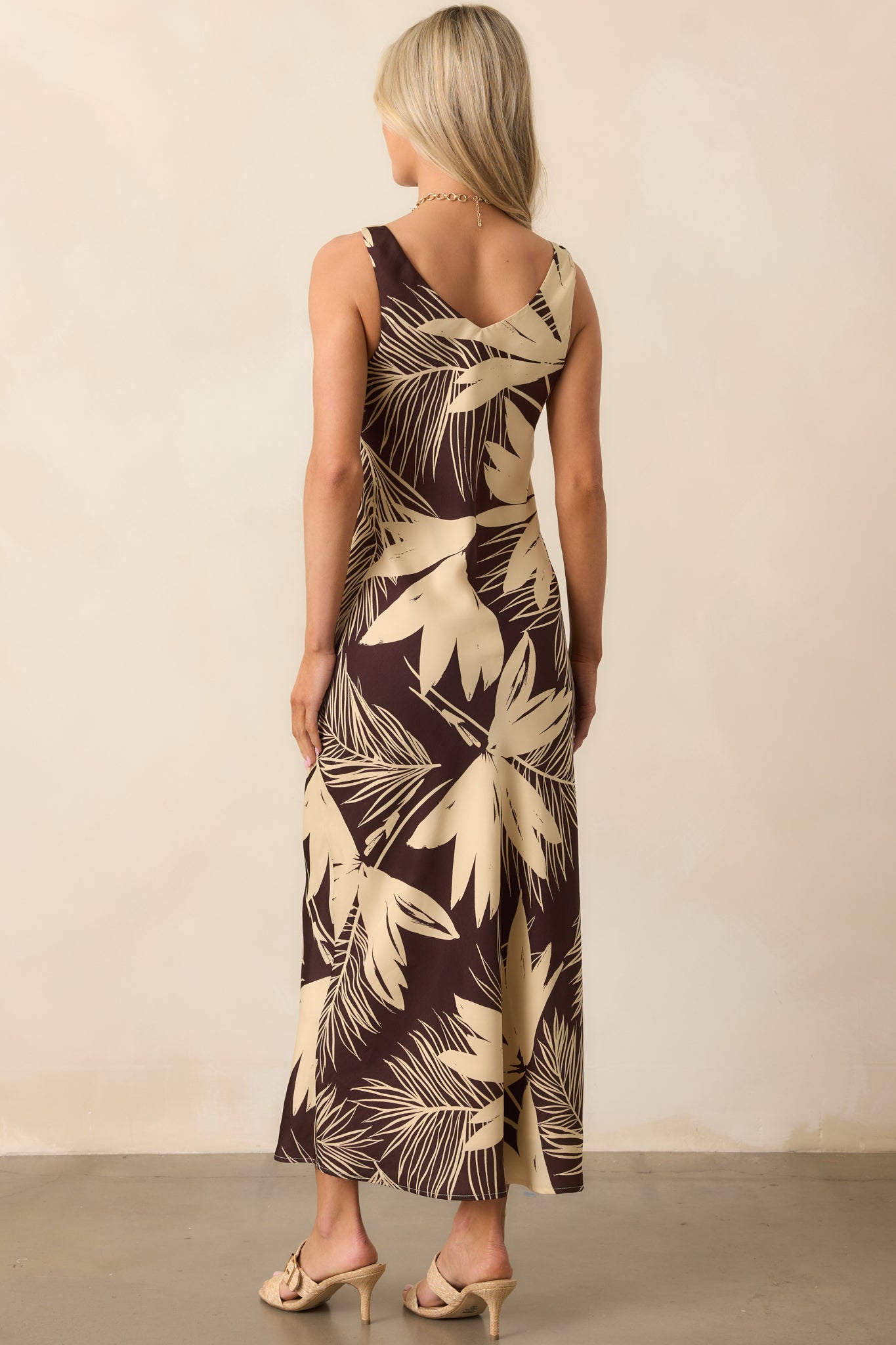 A view from behind of the floral dress showing the relaxed fit and continuous brown and ivory print.