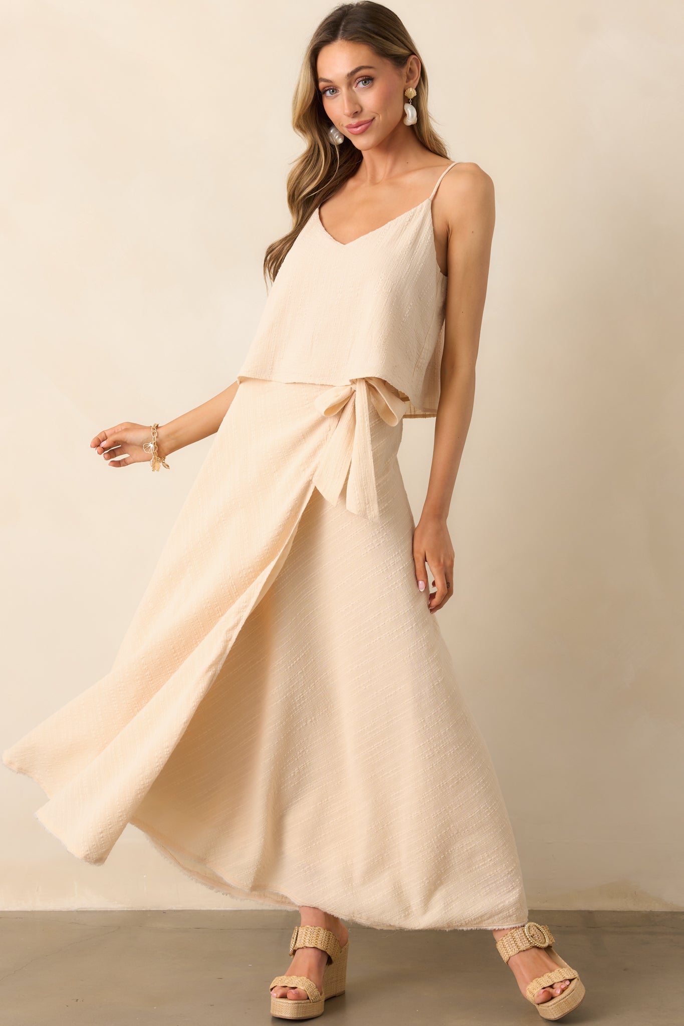 Beige high-waisted skirt with a self-tie wrap design and a raw-edge hemline with subtle fraying.