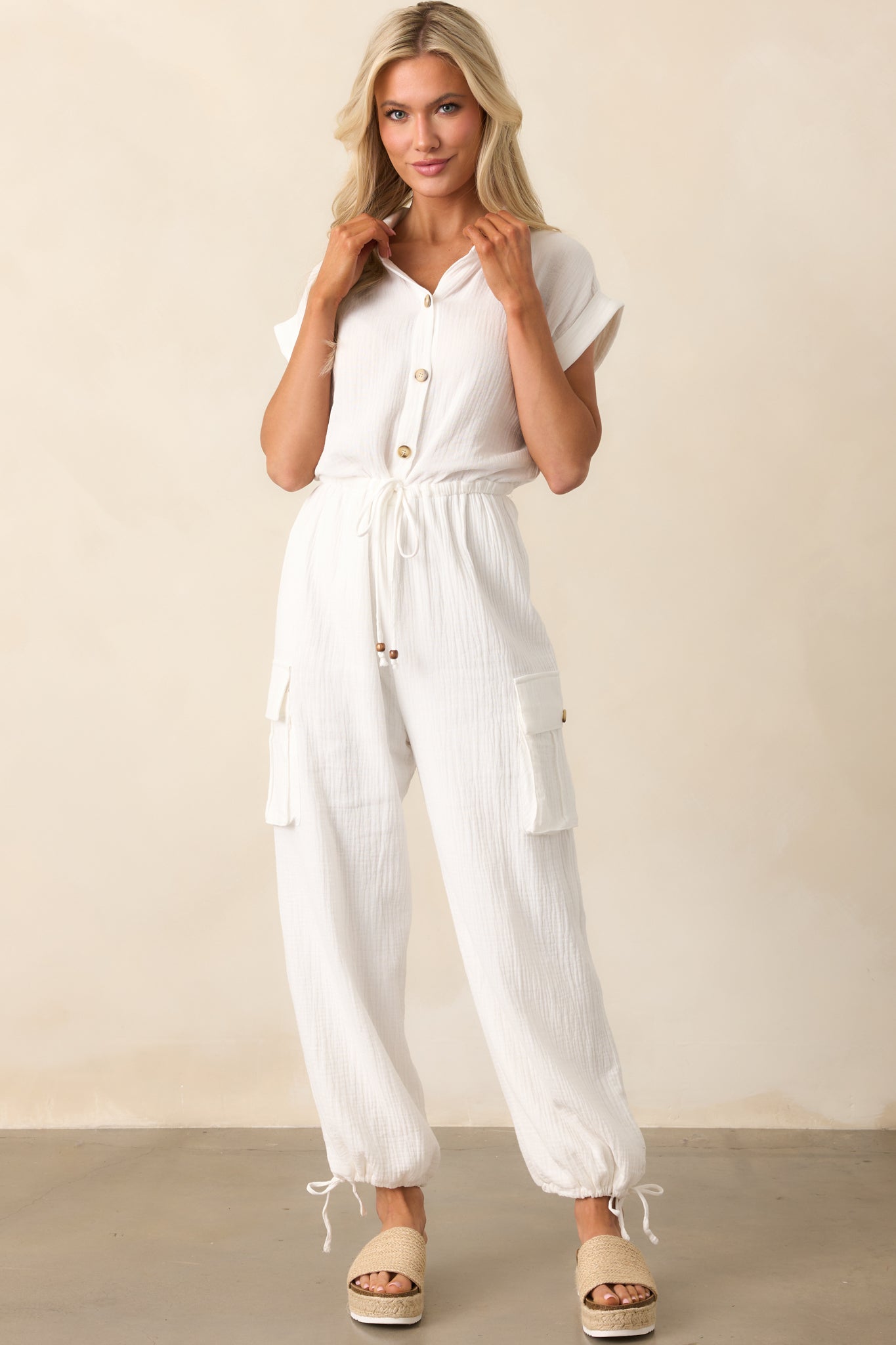 The jumpsuit shown from the front highlighting its rich ivory hue, soft texture, and collared neckline.