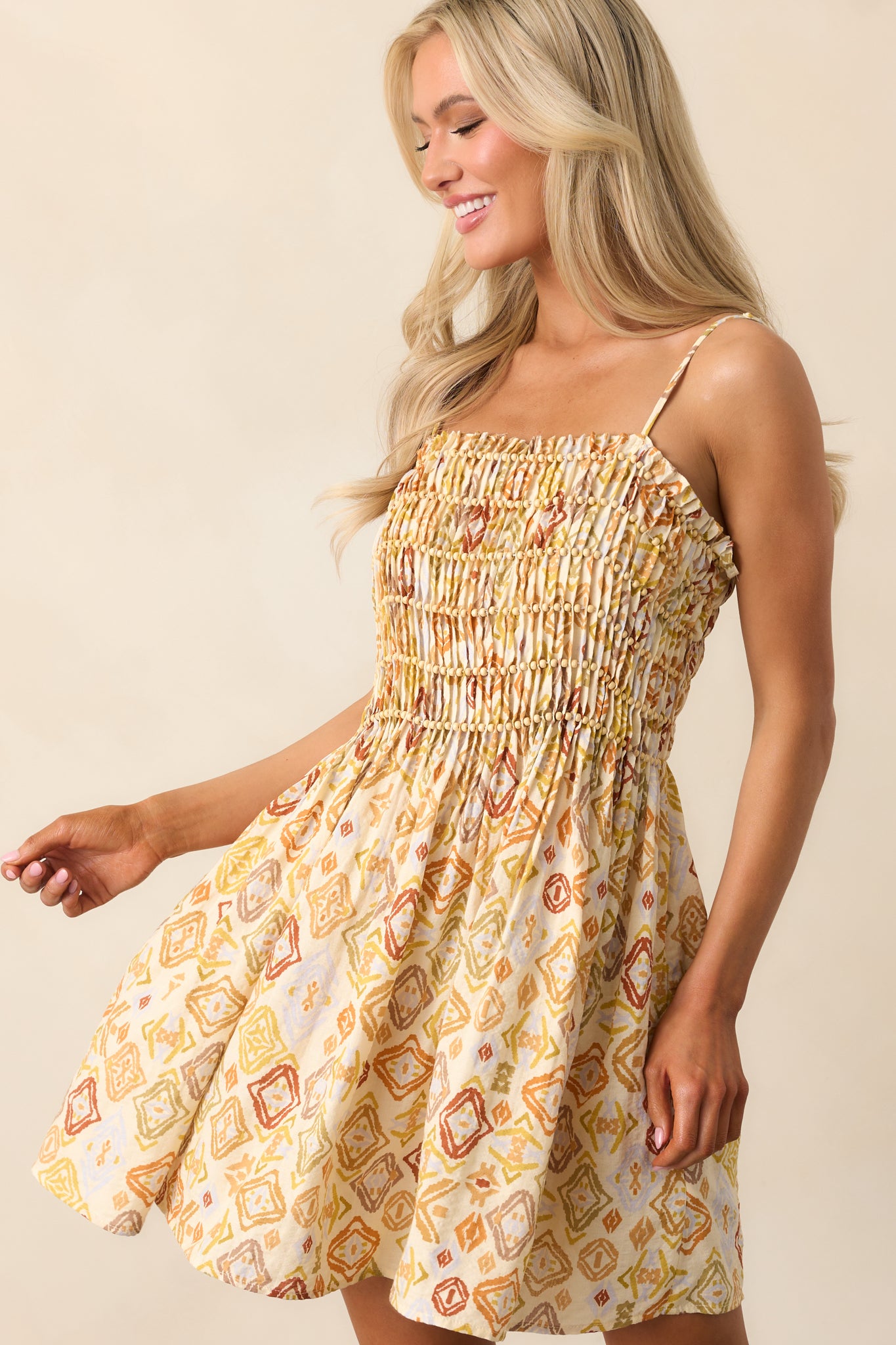 A detailed view of the pleated smocked bodice, showcasing the intricate beaded detailing.